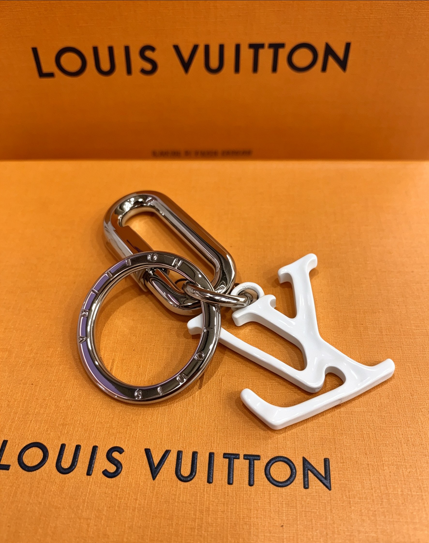 Louis Vuitton 本季腰带上的醒目搭扣化身为 1V Shape 包饰与钥匙扣 是一款标新立异的品牌标识