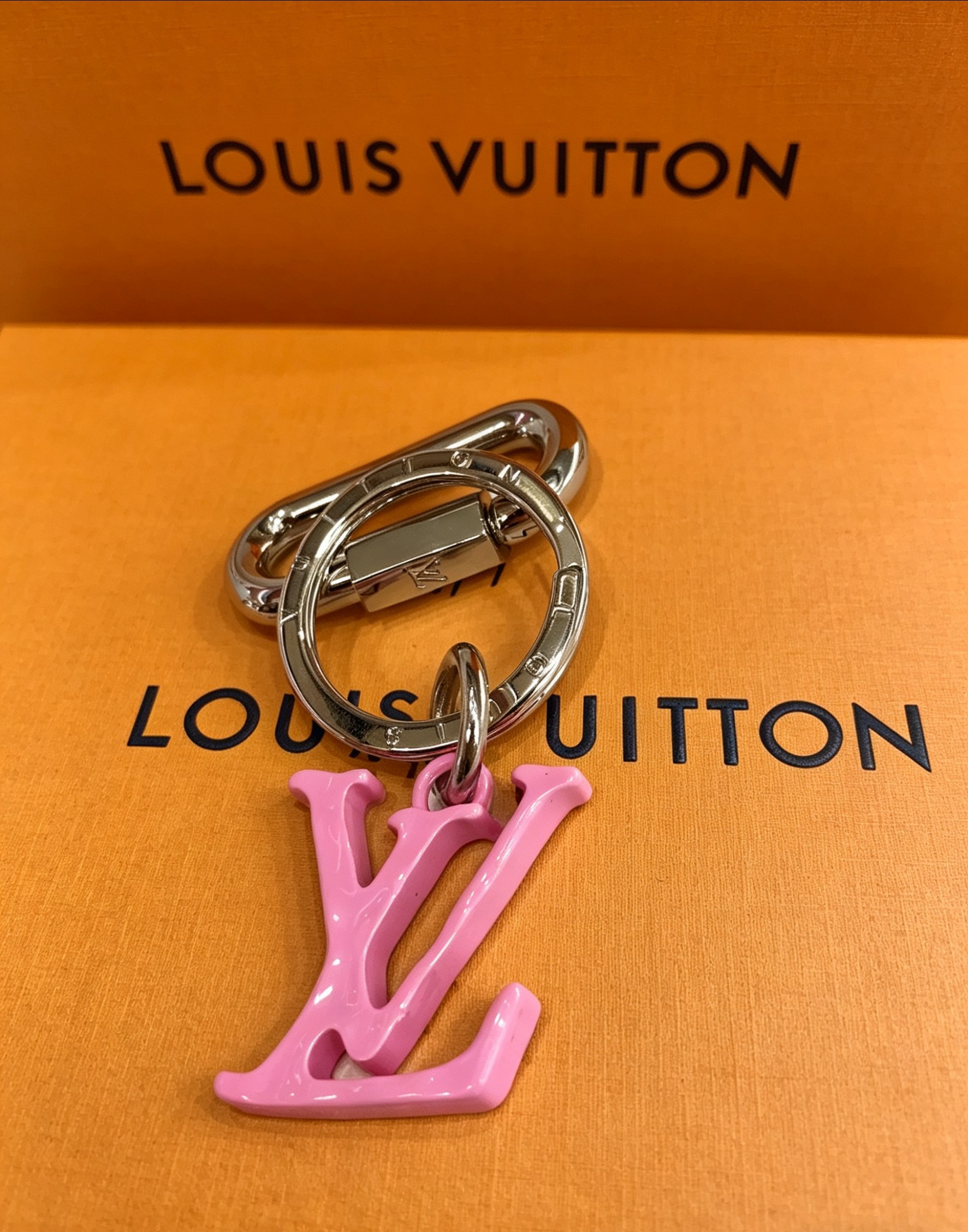 Louis Vuitton 本季腰带上的醒目搭扣化身为 1V Shape 包饰与钥匙扣 是一款标新立异的品牌标识