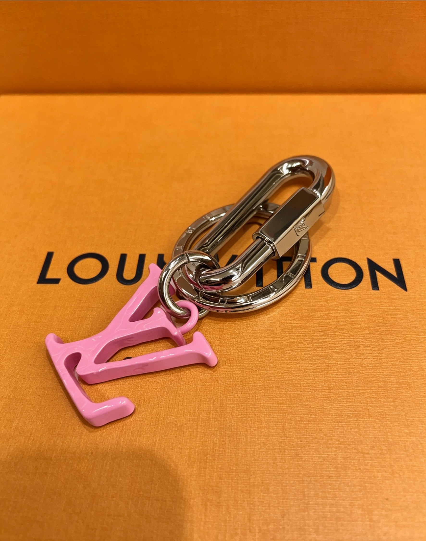 Louis Vuitton 本季腰带上的醒目搭扣化身为 1V Shape 包饰与钥匙扣 是一款标新立异的品牌标识