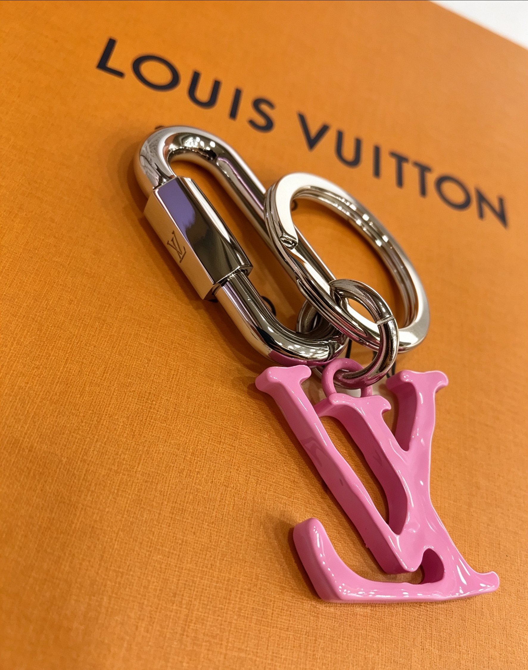 Louis Vuitton 本季腰带上的醒目搭扣化身为 1V Shape 包饰与钥匙扣 是一款标新立异的品牌标识