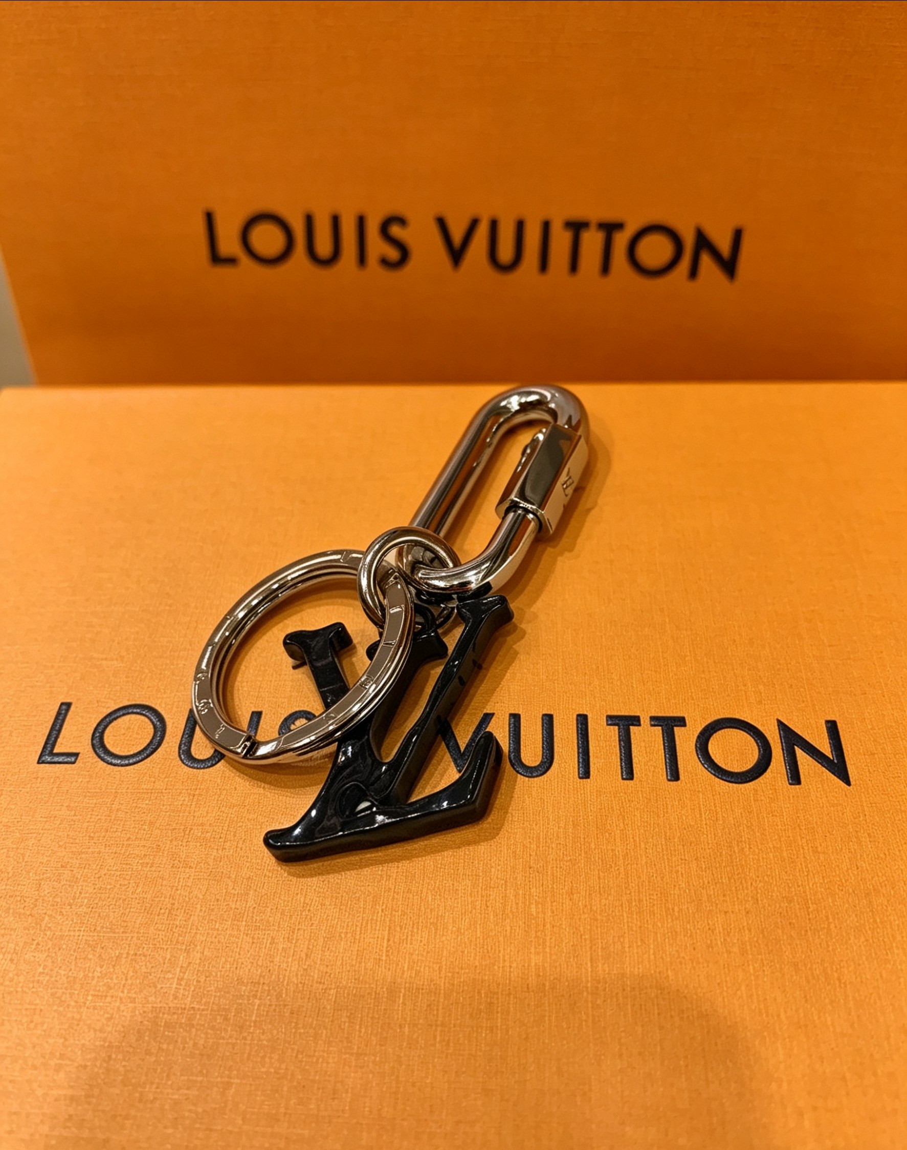 Louis Vuitton 本季腰带上的醒目搭扣化身为 1V Shape 包饰与钥匙扣 是一款标新立异的品牌标识