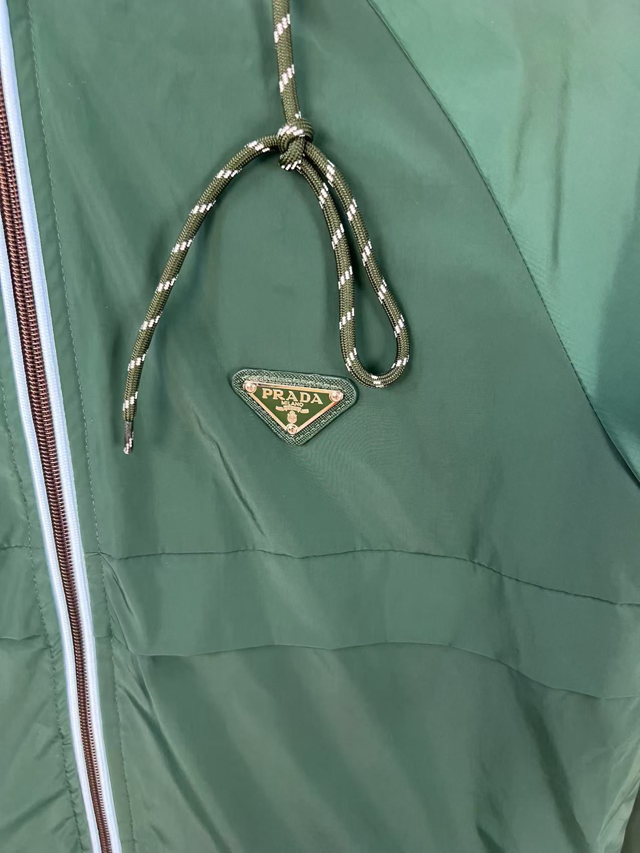 P190✨✨
 Prada 普拉达 2025秋冬新款 连帽风衣夹克外套 冲锋衣 胸前三角标刺绣 官网同步   原版定做五金拉链 走线工整 上身效果完美 男士休闲外套
颜色：墨绿色
尺码：M-3XL