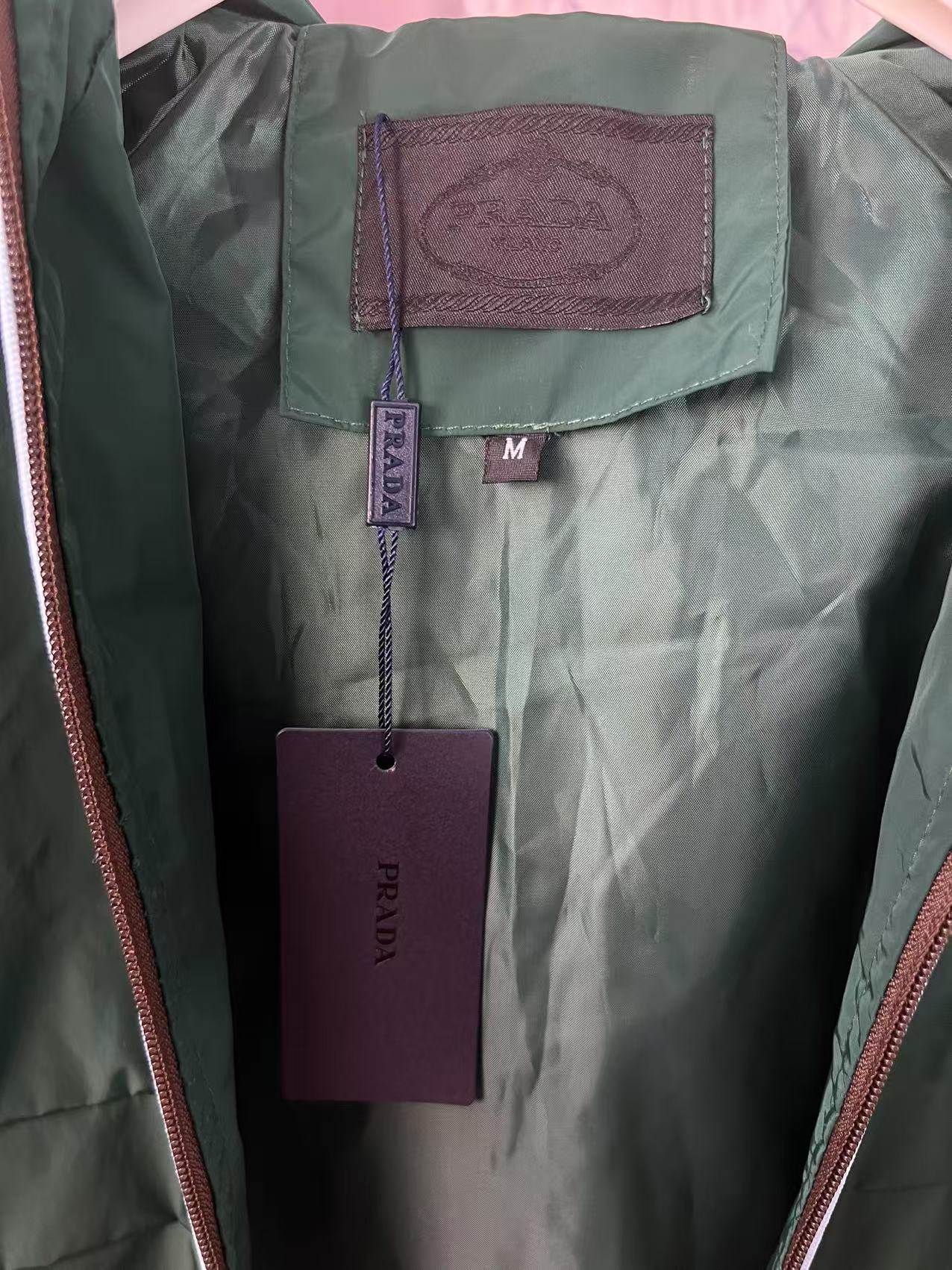 P190✨✨
 Prada 普拉达 2025秋冬新款 连帽风衣夹克外套 冲锋衣 胸前三角标刺绣 官网同步   原版定做五金拉链 走线工整 上身效果完美 男士休闲外套
颜色：墨绿色
尺码：M-3XL
