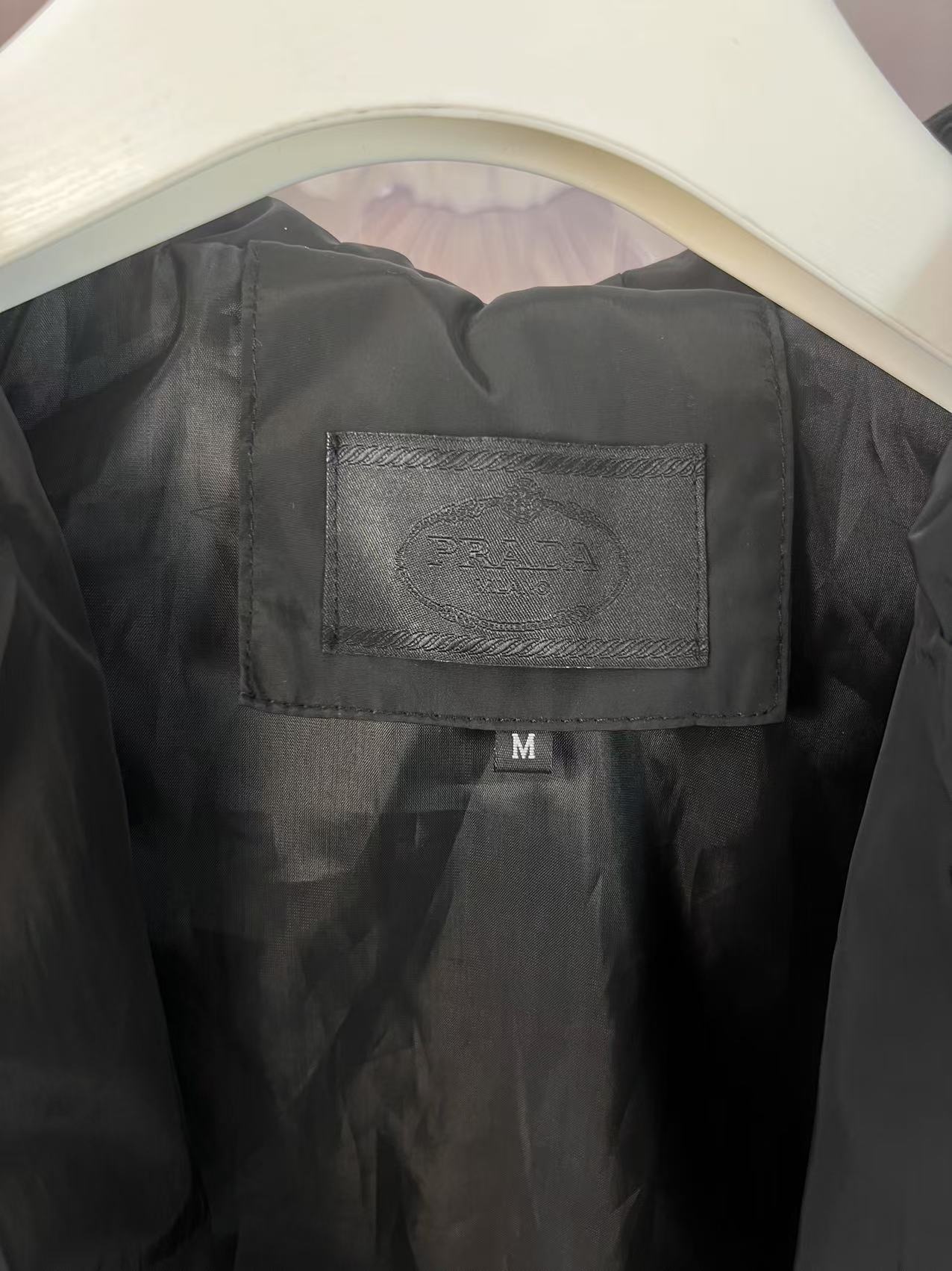 P190✨✨
 Prada 普拉达 2025秋冬新款 连帽风衣夹克外套 薄款冲锋衣 袖子口袋三角标刺绣 官网同步   原版定做五金拉链 走线工整 上身效果完美 男士休闲外套
颜色：黑色
尺码：M-3XL
