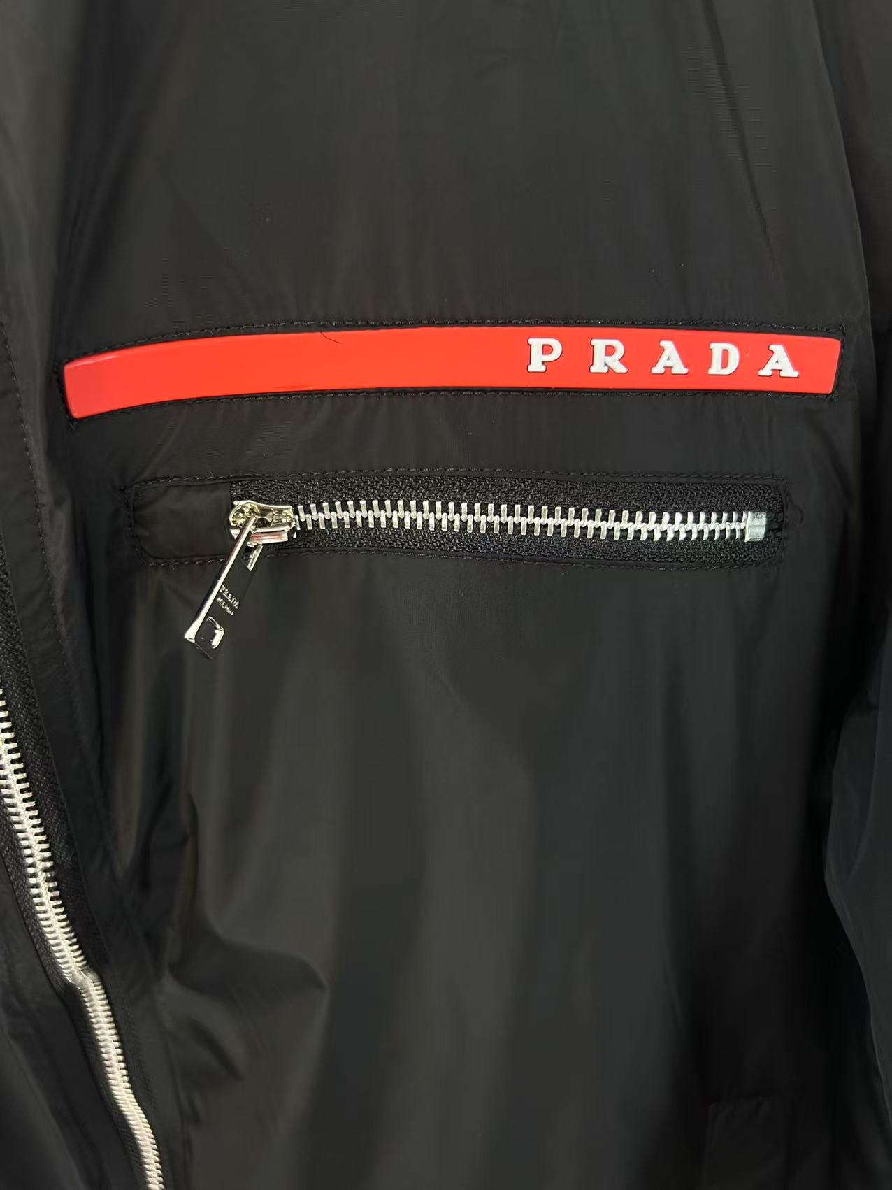 P190✨✨
 Prada 普拉达 2025秋冬新款 立领飞行风衣夹克外套 章仔拉链口袋 官网同步   原版定做五金拉链 走线工整 上身效果完美 男士休闲外套
颜色：黑色 
尺码：M-3XL