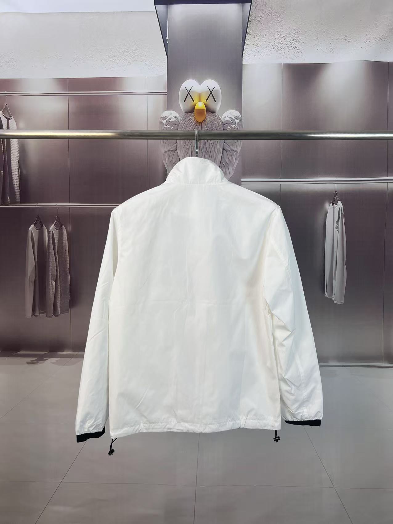 P190✨✨
 Prada 普拉达 2025秋冬新款 立领风衣夹克外套 薄款冲锋衣 经典红胶条logo 官网同步   原版定做五金拉链 走线工整 上身效果完美 男士休闲外套
颜色：白色
尺码：M-3XL