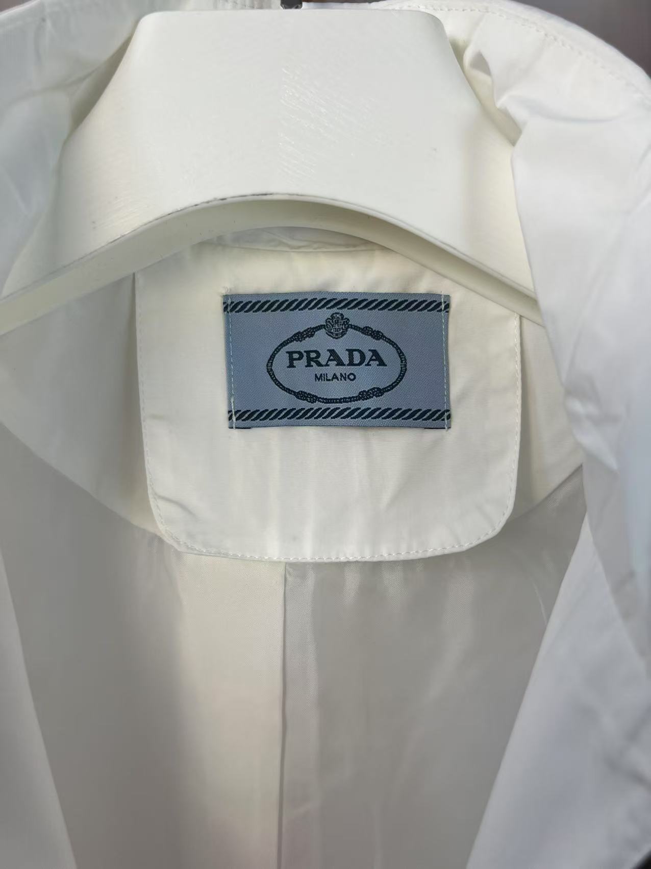 P190✨✨
 Prada 普拉达 2025秋冬新款 立领风衣夹克外套 薄款冲锋衣 经典红胶条logo 官网同步   原版定做五金拉链 走线工整 上身效果完美 男士休闲外套
颜色：白色
尺码：M-3XL