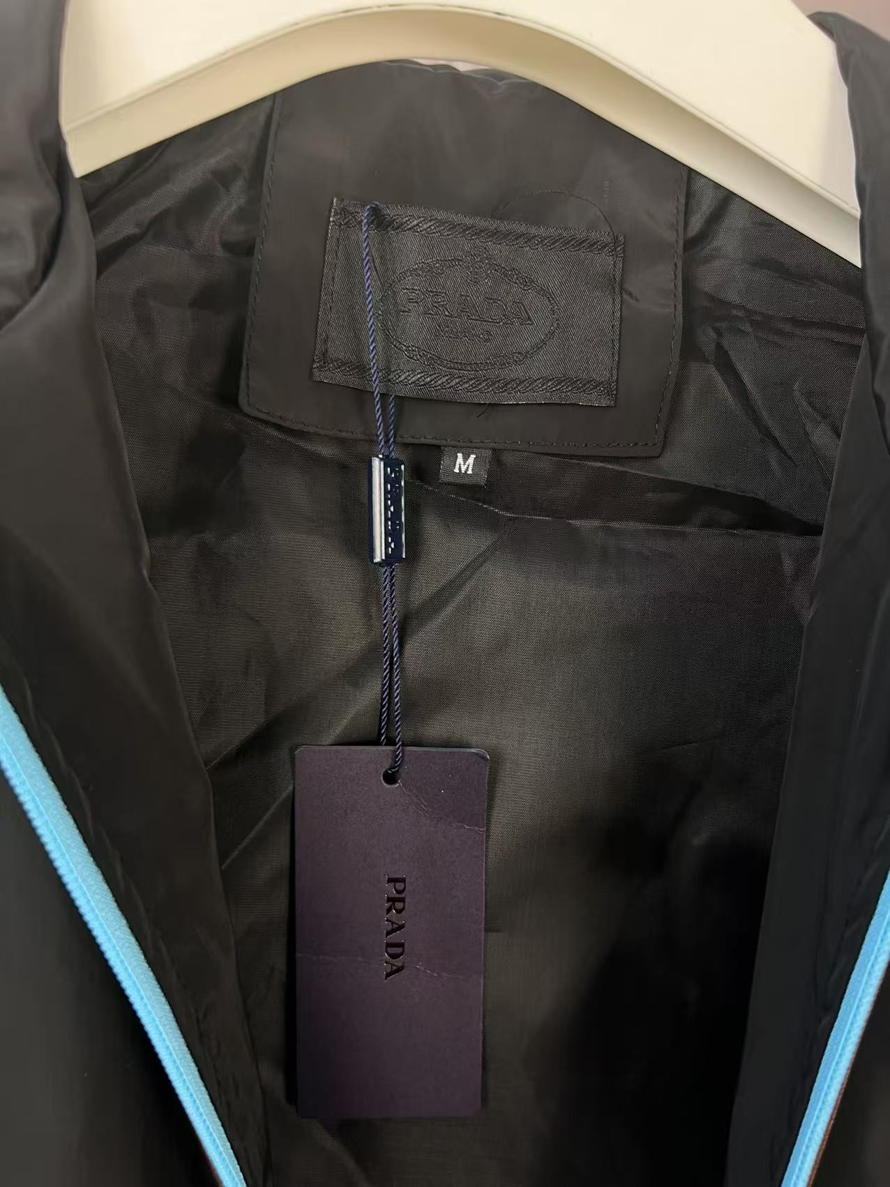 P190✨✨
 Prada 普拉达 2025秋冬新款 连帽风衣夹克外套 冲锋衣 胸前三角标刺绣 官网同步   原版定做五金拉链 走线工整 上身效果完美 男士休闲外套
颜色：黑色 
尺码：M-3XL