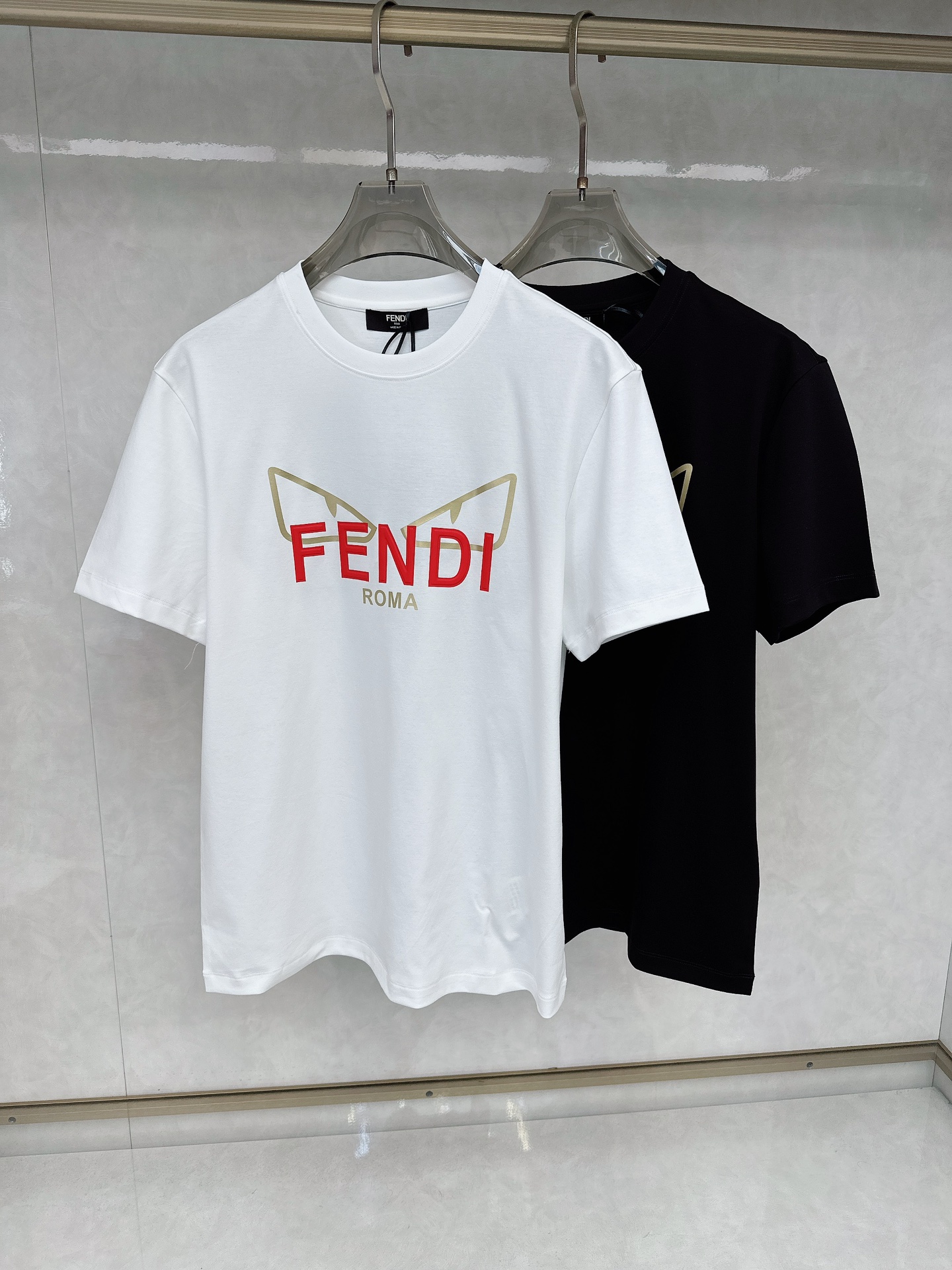 NO:117053,Fendi 25SS Spring and Summer New T standard style short-sleeved round neck T-shirt. Black and white pure cotton material. The 100th anniversary limited edition style is decorated with customized FENDI Roma lettering and red and gold FENDI Eyes pattern printing. This T-shirt is novel and unique, made of pure cotton material, comfortable and breathable, suitable for spring and summer wear. The leather embroidered monster eye pattern on the chest shows the brand's unique design style, fashionable and interesting. The loose style design is casual and comfortable to wear, suitable for people of all body types. Overall, this T-shirt shows the Fendi brand's consistent high quality and fashion sense, the best choice for spring and summer. Color black and white Number of codes: M-3XL,,fendi,fendi,T-shirt,tees,t-shirt,alexander wang19860909芬迪 25SS春夏新款T 标准版型短袖圆领T恤.黑白 纯棉材质.正100周年限量款面饰有定制的FENDI Roma字样以及红色和金色 FENDI Eyes图案印花.这款T恤设计新颖独特,采用纯棉材质打造,穿着舒适透气,适合春夏季节穿着.胸前皮质刺绣小怪兽眼睛图案,展现了品牌的独特设计风格,时尚而富有趣味性.宽松的版型设计,穿着随意自在,适合各种体型的人士. 整体上,这款T恤展现出了芬迪品牌一贯的高品质和时尚感, 春夏季节的不二之选. 颜色黑白 码数:M-3XL,,fendi,fendi,T-shirt,tees，t-shirt,alexander wang,Men's clothing