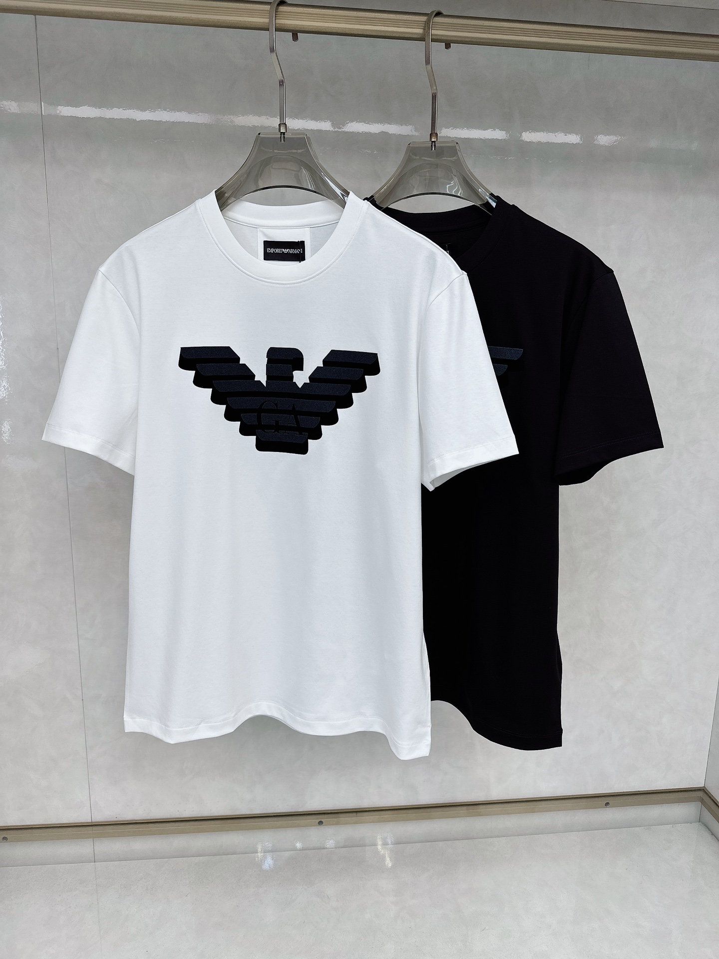 NO:117055,Armani EMPORIO ARMANI25SS short-sleeved T-shirt is made of soft and skin-friendly cotton fabric, with a standard round neck and short-sleeved cut, which is more suitable for daily wear. Simple and yet designed. The collar ring is decorated with flocked eagle logo on the front, presenting a unique velvet embossed texture, cleverly combining brand sense and design, suitable for creating a casual and urban-style modern style. The simple round neck collar shape can modify various face shapes and is essential for men's wardrobe. Color black and white Number M-3XL,,armani,armani,T-shirt,tees,t-shirt,alexander wang19860909阿玛尼 EMPORIO ARMANI25SS短袖T恤 甄选软糯亲肤的全棉面料制成,标准版圆领短袖裁剪,更适合日常穿着.简约不失设计感, 领圈0.3cm边线正面饰有植绒鹰标,呈现别具一格的天鹅绒压花质感,将品牌 感与设计巧妙结合,适合打造休闲率性的现代都市感造型. 简约的圆领领型,能够修饰各种脸型,气质男人衣柜必备款式. 颜色黑白 码数M-3XL,,armani,armani,T-shirt,tees，t-shirt,alexander wang,Men's clothing