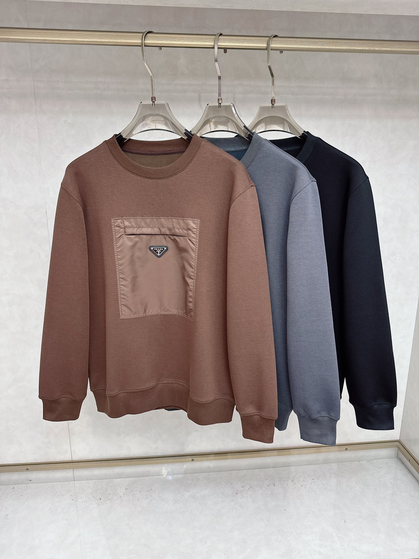 NO:527026,Prada Pr**a 2025 Fall and Winter Quality Control Recommendation Classic round-neck pullover sweater The chest splicing and nameplate embellishment design makes the overall fashionable and highlights. Knitted threads Not easy to fit. Combined style The fabric uses Austrian modal fiber. It is known as the breathable air-layer fabric. Through the structural design, it adopts three pieces of fabric structures of inner, middle and outer, so as to form an air interlayer in the fabric. It has good fluffy and feels Q-elastic. It forms a static air layer to achieve warmth, with good wrinkle resistance, soft and comfortable, smooth and breathable warm fabric has a good backbone, and the overall upper body is upright and stylish!  Color black grey brown code M-3XL, prada, hoodie, sweatshirts, alexander wang19860909普拉达Pr**a 2025秋冬 品质控推荐 经典款圆领套头卫衣 胸前拼接结合铭牌点缀设计 让整体时尚而有亮点 针织螺纹 不易版型 合体的版型 面料采用 奥地利莫代尔纤维 被誉为会呼吸的空气层面料,通过结构设计采用里、中、外三片的织物结构,从而在织物中形成空气夹层 .蓬松性好 手感Q弹力.以形成静止空气层,从而达到保暖效果,抗皱性佳入手柔软舒适,亲 肤爽滑透气保暖面料整体又有着很好的骨干,整体上身挺拔有型！颜色黑色 灰色 咖色 码数M-3XL,,prada,hoodie,sweatshirts,alexander wang,Men's clothing