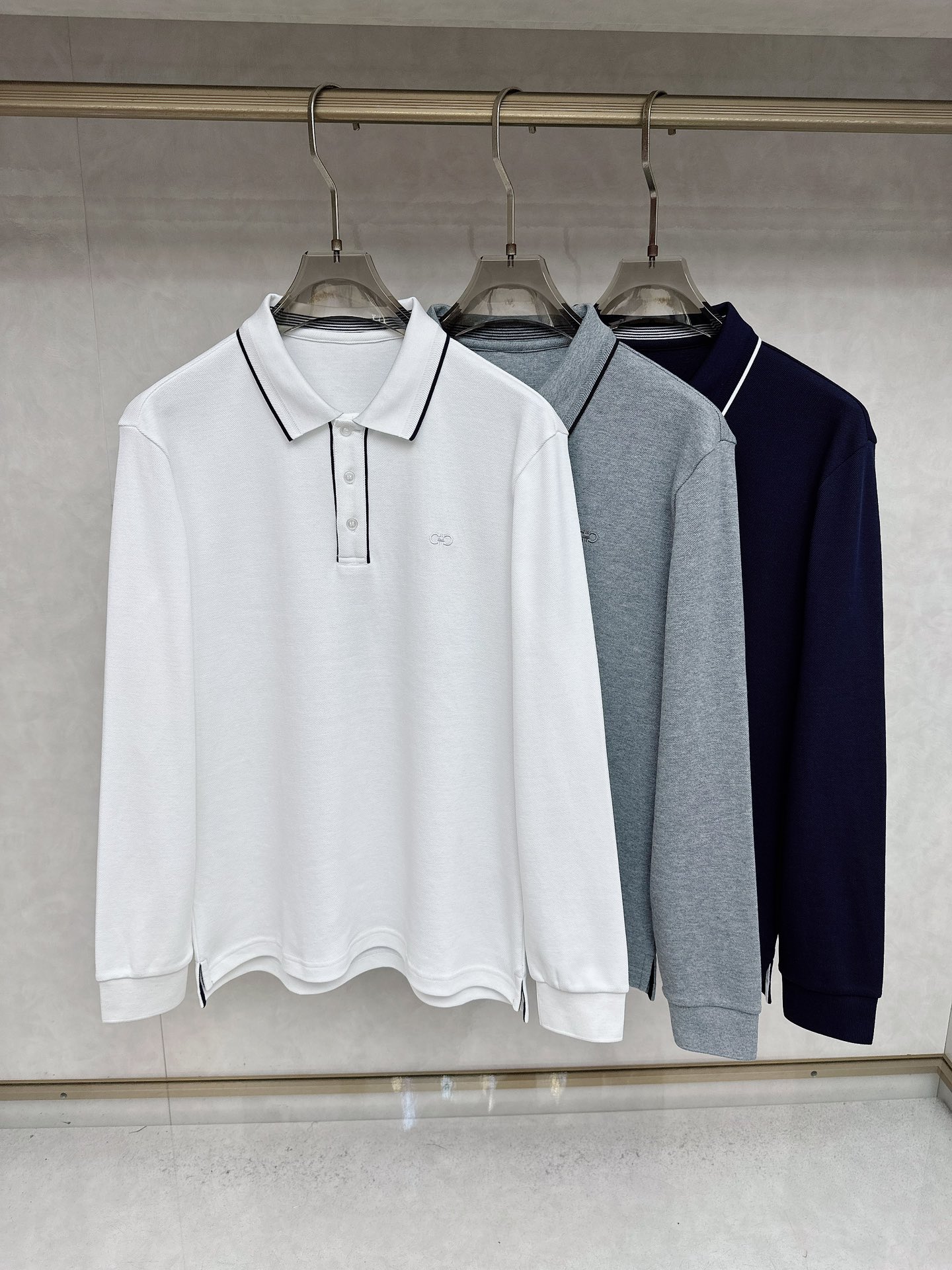 NO:568309,Ferragamo's 2025 early autumn new model - high-end business casual POLO shirt with horseshoe embroidery logo. Born because of classics, the signature item that must be released every season is reincarnated in every season. The new season still continues the design tone of the house, which is generally undifferentiated. Striped elements are mixed in the details, which is very fashionable, elegant, age-reducing and retro. It forms an aesthetic contrast visually and can easily highlight the elements of temperament and taste!  We provide customers with high-end imported ready-made custom-woven pique fabrics, which are extremely luxurious and special materials. The fabric properties are all of the best. The stripes are made of exquisite yarn-dyed technology. The fabric has high gloss, the mesh structure is delicate and natural, and it has perfect comfort and breathability. The tactile experience is self-evident, and you can enjoy the ultimate luxury!  The details are exquisite and the appearance is first-class. The three-button placket closure, small lapel design, and the iconic Gancio horseshoe embroidery on the chest are quite exquisite and have a soul-like existence, highlighting the noble brand identity!  The upper body effect is excellent, and it can be mixed and matched for commuting or leisure. It can easily interpret the ultra-stylish urban elite feel. It is a highly controllable item!  Color Navy White Gray Size M L  XXL code: bust 118cm - dress length 73cm - shoulder width 49cm - sleeve length 64cm XXXL code: bust 122cm - dress length 74cm - shoulder width 50cm - sleeve length 65cm,,ferragamo,alexander wang19860909菲拉格慕 2025早秋新款-马蹄刺绣标识高端商务休闲POLO衫马球衫.因经典而生,每季必出的招牌单品,在每一季轮回,新一季仍然延续了家的设计基调,大体无差异化,在细节上面混搭了条纹元素,非常时髦优雅减龄且复古,在视觉上形成审美反差,极易凸显气质与品位的元素！客供高级进口成衣定织珠地面料,极为奢华特殊的材质,面料属性皆为上乘,条纹采用精湛的色织工艺打造而成,面料光泽度极高,网眼结构细腻自然,舒适性与透气性完美兼备,触感体验不言而喻,奢华极致享受！细节精湛考究,品相一流,三扣门襟开合,小翻领设计,胸前标志性的 Gancio 马蹄刺绣体点缀,颇为精致,属于灵魂式的存在,彰显了高贵的品牌身份！上身效果出色,即通勤亦休闲混搭,可以轻松诠释出超具型格的都市精英感,属于驾驭度极高的单品！ 颜色藏青色 白色 灰色 尺码M L XL XXL XXXL 尺码数据 M码:胸围106cm-衣长70cm-肩宽46cm-袖长61cm L码:胸围110cm-衣长71cm-肩宽47cm-袖长62cm XL码:胸围114cm-衣长70cm-肩宽48cm-袖长63cm XXL码:胸围118cm-衣长73cm-肩宽49cm-袖长64cm XXXL码:胸围122cm-衣长74cm-肩宽50cm-袖长65cm,,ferragamo,alexander wang,Men's clothing