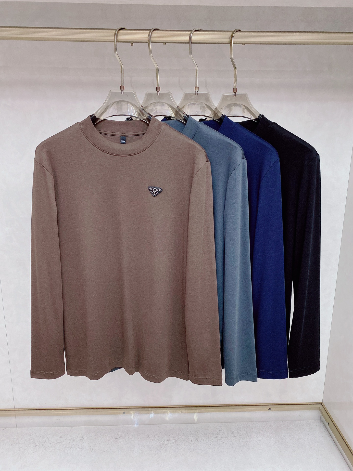 NO:540775,Prada 2025's latest early autumn products, available at the same time, original singles, fashionable and casual round neck long-sleeved T-shirt, using imported original fabric, comfortable and breathable, craft letter pattern decoration logo, the upper body is very handsome. Number M-3XL, prada,tees, t-shirt, alexander wang19860909普拉达 2025早秋最新品,同步有售,原单狠货,时尚休闲圆领长袖T恤,采用进口原版面料,舒适透气,工艺字母图案装饰logo,上身帅气十足 码数M-3XL,,prada,tees，t-shirt,alexander wang,Men's clothing