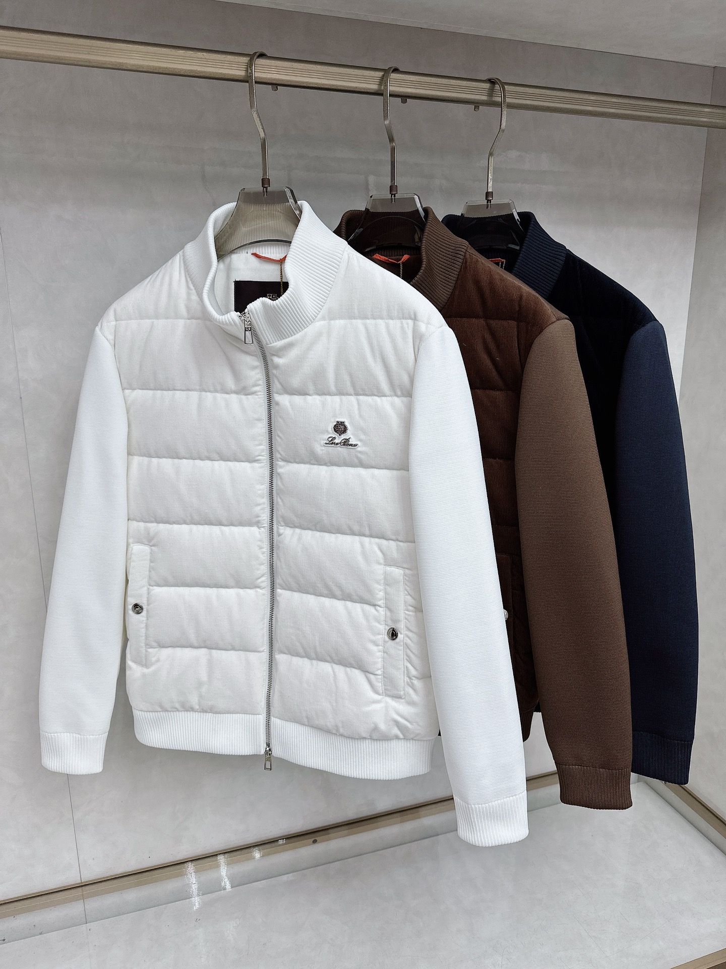 NO:626753,Loro Piana's new down jacket for autumn and winter 2025 interprets high-end outdoor aesthetics with minimalism. The style adopts a stand-up collar design with a smooth silver zipper, the brand's iconic logo is embellished on the left chest, and practical pockets with buttons are symmetrically designed on both sides. The cuffs and hem are ribbed to enhance warmth and fit.  Its design combines Alpine genes with modern urban style. It can be paired with casual trousers to create a daily look, and can also meet the needs of light outdoor activities. From urban commuting to outings in the suburbs, this down jacket, with its pure white tone and exquisite craftsmanship details, has become a winter model that connects high-end quality and practical functions, interpreting Loro Piana's ultimate pursuit of materials and craftsmanship. 48-56,,loro piana,down jacket,alexander wang19860909Loro Piana诺悠翩雅、2025秋冬新款羽绒服,以极简主义诠释高端户外美学.款式采用立领设计搭配顺滑银色拉链,左胸点缀品牌标志性徽标,两侧对称设计带纽扣的实用口袋.袖口与下摆采用罗纹收边工艺,增强保暖性能与贴合度. 其设计将阿尔卑斯山系基因与现代都市风格相融合,可搭配休闲长裤打造日常造型,亦能满足轻度户外活动需求.从城市通勤到郊外出行,这款羽绒服以纯净白色调与精湛工艺细节,成为连接高端品质与实用功能的冬季典范,诠释Loro Piana对材质与工艺的极致追求.48-56,,loro piana,down jacket,alexander wang,Men's clothing
