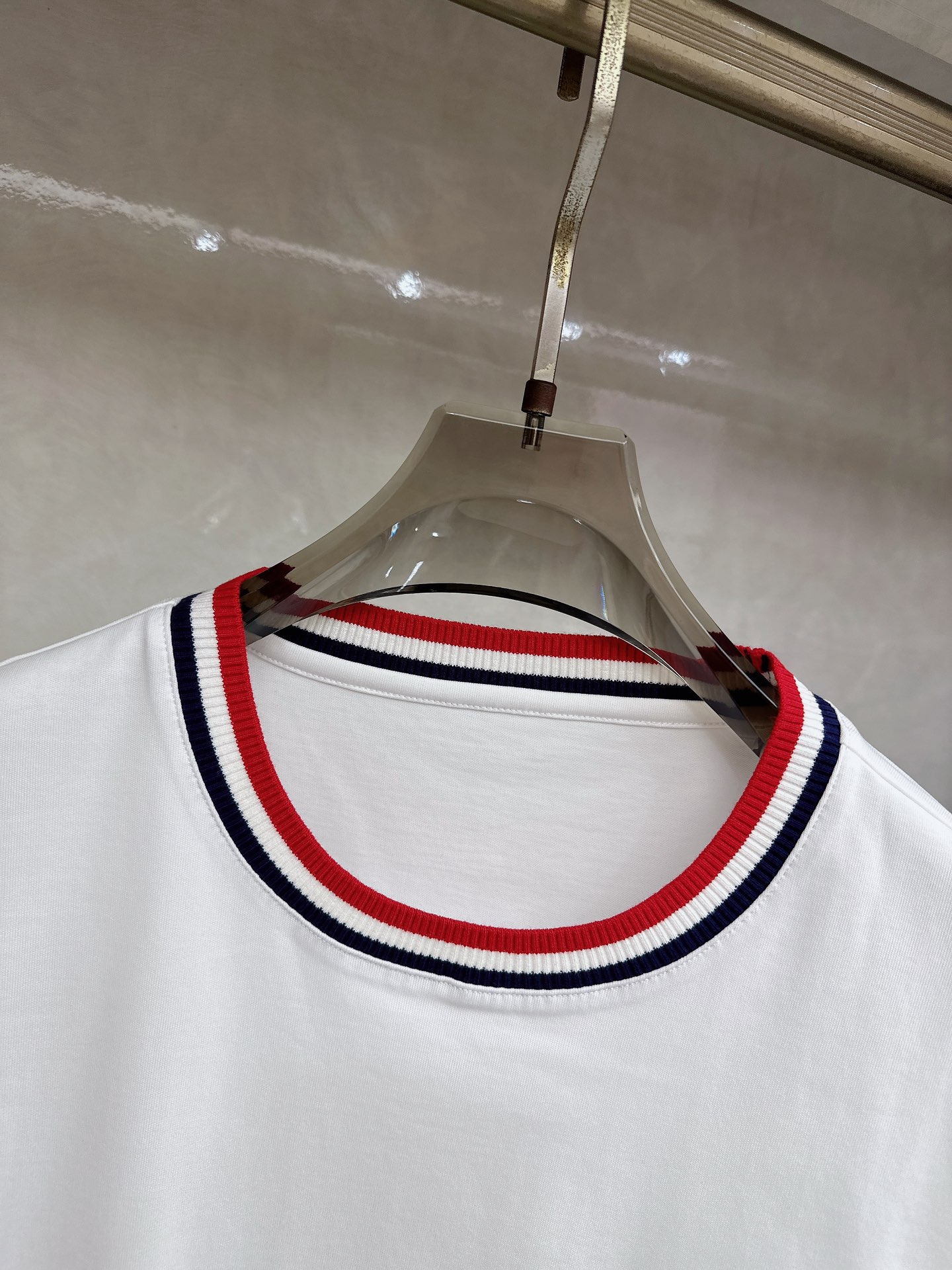 蒙口 2026春夏新款 圆领短袖 领部的采用针织红白蓝设计 很有亮点 上身时尚而有细节 胸口与肩部铭牌刺