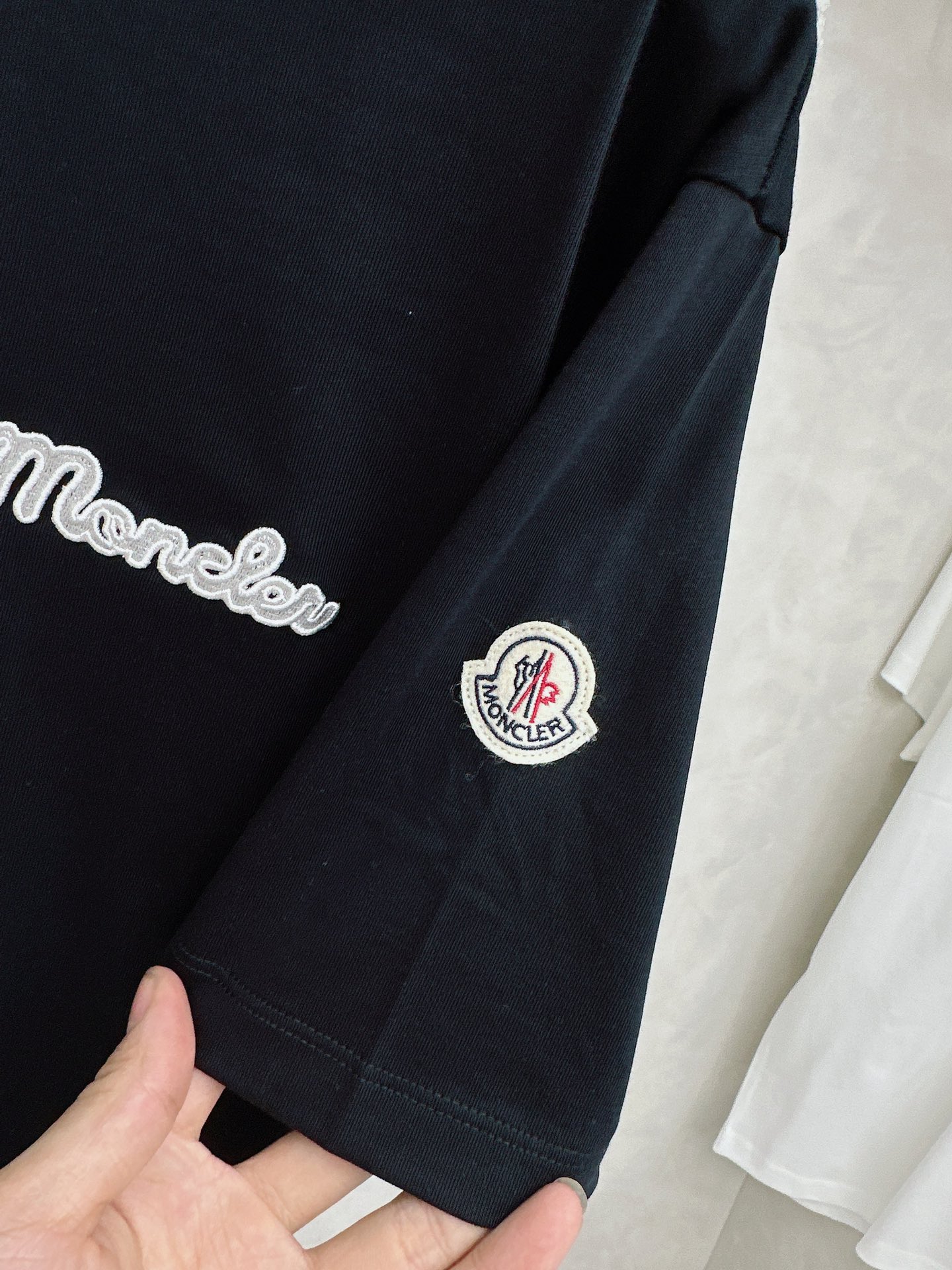 蒙口 2026春夏新款 圆领短袖 领部的采用针织红白蓝设计 很有亮点 上身时尚而有细节 胸口与肩部铭牌刺