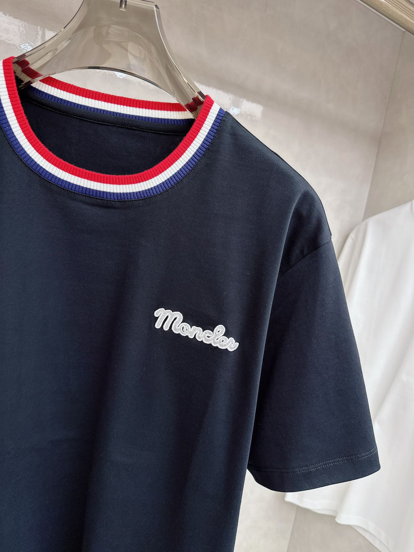 蒙口 2026春夏新款 圆领短袖 领部的采用针织红白蓝设计 很有亮点 上身时尚而有细节 胸口与肩部铭牌刺