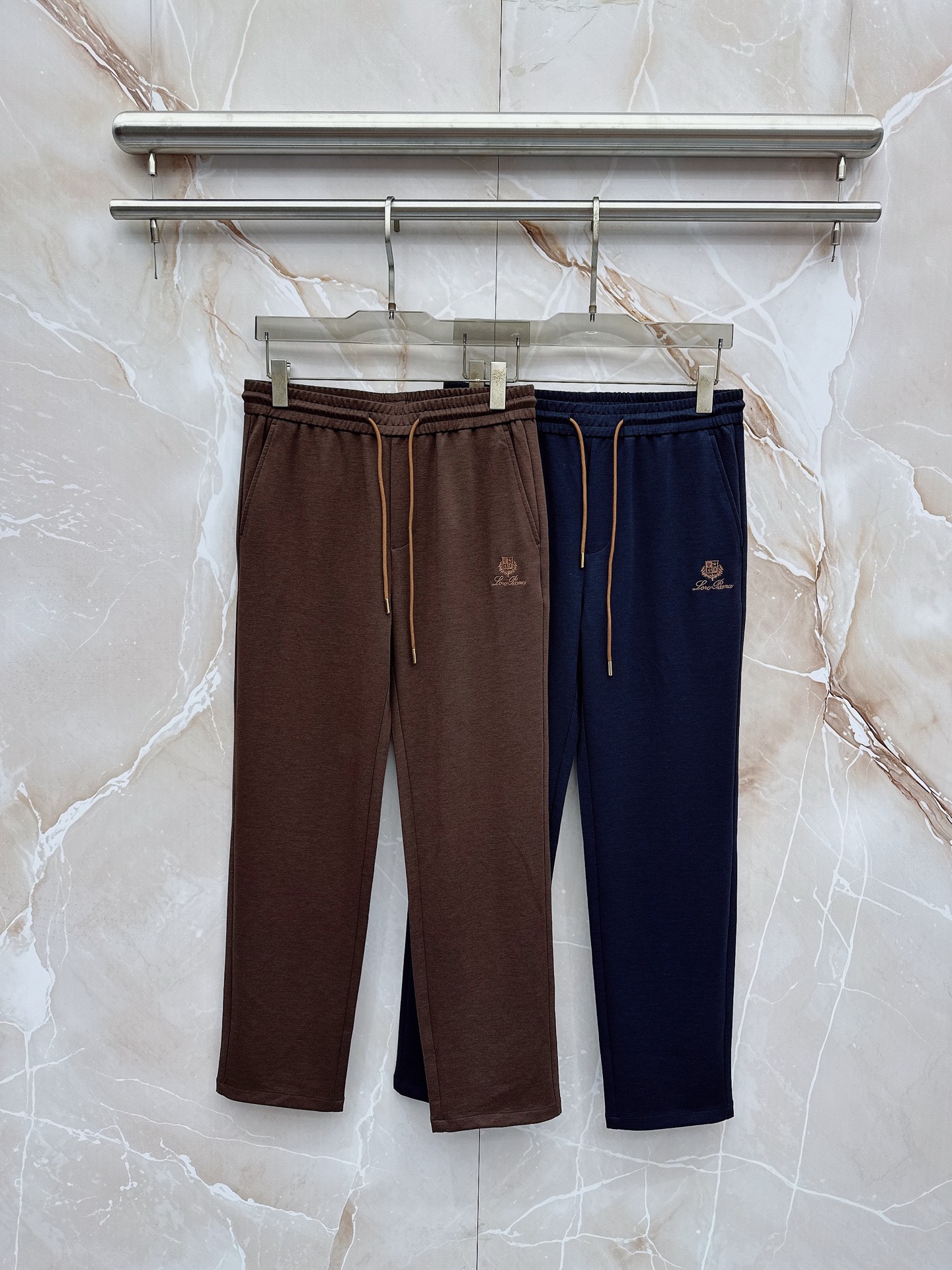NO:839511,LP Nuoyoupanya embroidered logo drawstring casual pants are made from the brand's exclusive top-grade blended technical fabrics. They feel as delicate and soft as cashmere, with a soft matte texture. They have excellent drape and anti-wrinkle properties. They are not prone to deformation and pilling after long-term wear. They are breathable, skin-friendly and not stuffy.  The waistband adopts a widened and high-elastic elastic design, with brown leather-edged drawstrings and metal-textured rope ends. The pull-out is smooth and not stuck, and the neat pleat lines are smooth and not stiff. It not only modifies the waist and abdomen lines, but also retains the room for movement, taking into account the elegant silhouette and daily comfort, fully demonstrating the brand's ingenious tailoring.  The side seams of the trousers adopt three-dimensional hemming technology, the lines are smooth and neat, and the pockets are invisible, making them neat, stylish and practical. The trousers are embellished with exquisite brand embroidery logos, low-key highlighting the brand texture, and adding layers and recognition to the simple trousers. 48-56,, loro piana,19860909LP诺悠翩雅刺绣徽标抽绳休闲裤 甄选品牌专属顶级混纺科技面料,触感细腻如羊绒般柔糯,自带柔光雾面质感,兼具出色垂坠感与抗皱性,久穿不易变形起球,透气亲肤不闷黏. 腰头采用加宽高弹松紧设计,搭配棕色皮质包边抽绳与金属质感绳头,抽拉顺滑不卡顿,利落收褶线条流畅不生硬,既修饰腰腹线条,又保留穿着活动余量,兼顾优雅版型与日常自在感,尽显品牌匠心剪裁. 裤身侧缝采用立体包边工艺,走线平整工整,口袋做了隐形处理,利落有型兼具实用性,裤身点缀精致品牌刺绣标识,低调彰显品牌质感,为简约裤身增添层次与辨识度.48-56,,loro piana,,Men's clothing