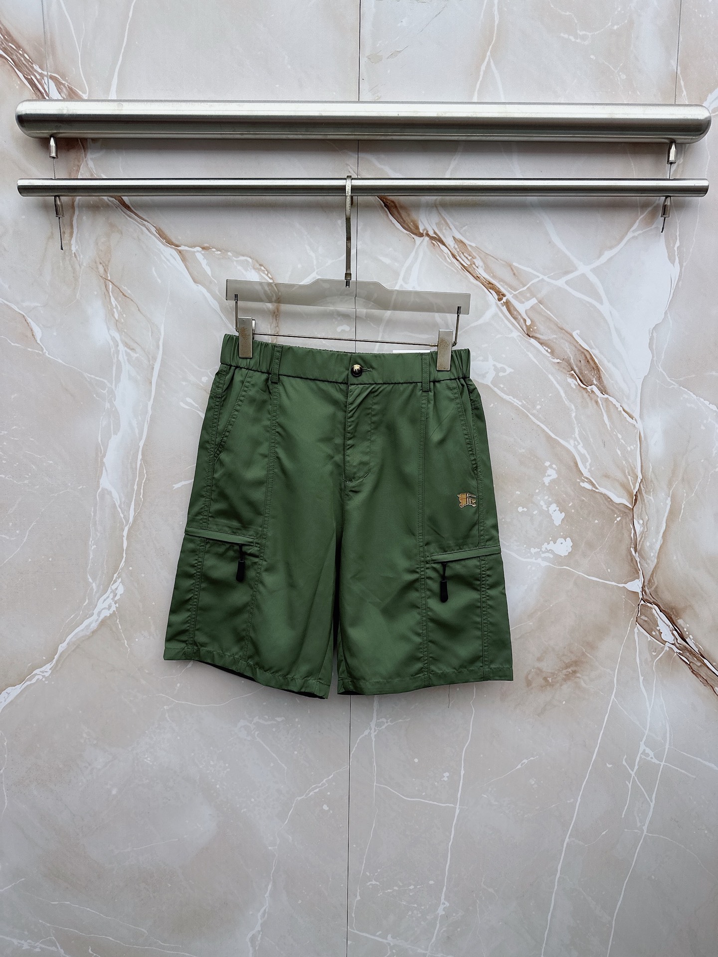 NO:907042,Burberry's 2026 spring and summer new cargo shorts continue the classic Cargo  Pocket design, two-dimensional three-dimensional large pockets on both sides combine practicality and style. The drawstring elastic waistband adapts to various body shapes and easily creates a casual street posture. The fabric is made of light and breathable cotton blend material, which is soft and skin-friendly, suitable for spring and summer wear.  The fabric is refreshing and not stuffy, and the drapey fabric naturally modifies the leg shape, giving it a lazy atmosphere when walking. The details are embellished with metal buttons and exquisite brand logos, highlighting quality in a low-key manner. The overall style combines the tough lines of Japanese workwear with American casual  They have a sense of leisure and relaxation, with neat silhouettes for outdoor functions, without losing the trendy attitude of urban streets. Whether it is daily commuting, weekend outings or sports and fitness, they can be easily controlled and show effortless fashion. In the spring and summer of 2026, make these work shorts a versatile tool in your wardrobe. It uses simple colors and practical designs to interpret the new generation of street aesthetics, and easily wears the perfect balance of high-end and comfort. M-4XL,, burberry, shorts,19860909巴宝莉 2026春夏新品工装短裤,延续经典Cargo Pocket设计,双侧立体大口袋兼具实用性与造型感,抽绳松紧腰头适配各种身形,轻松打造随性街头姿态.面料选用轻薄透气的棉质混纺材质,触感柔软亲肤,春夏穿着清爽不闷热,垂坠感十足的面料自然修饰腿型,走动间自带慵懒氛围.细节处点缀金属纽扣与精致品牌标识,低调中彰显品质.整体风格融合日系工装的硬朗线条与美式休闲的松弛感,既有户外机能的利落轮廓,又不失都市街头的潮流态度.无论是日常通勤、周末出游还是运动健身,都能轻松驾驭,展现不费力的时髦感.2026春夏,让这条工装短裤成为你衣橱里的百搭利器,用简约色彩与实用设计诠释新一代街头美学,轻松穿出高级感与舒适度的完美平衡.M-4XL,,burberry,shorts,,Men's clothing