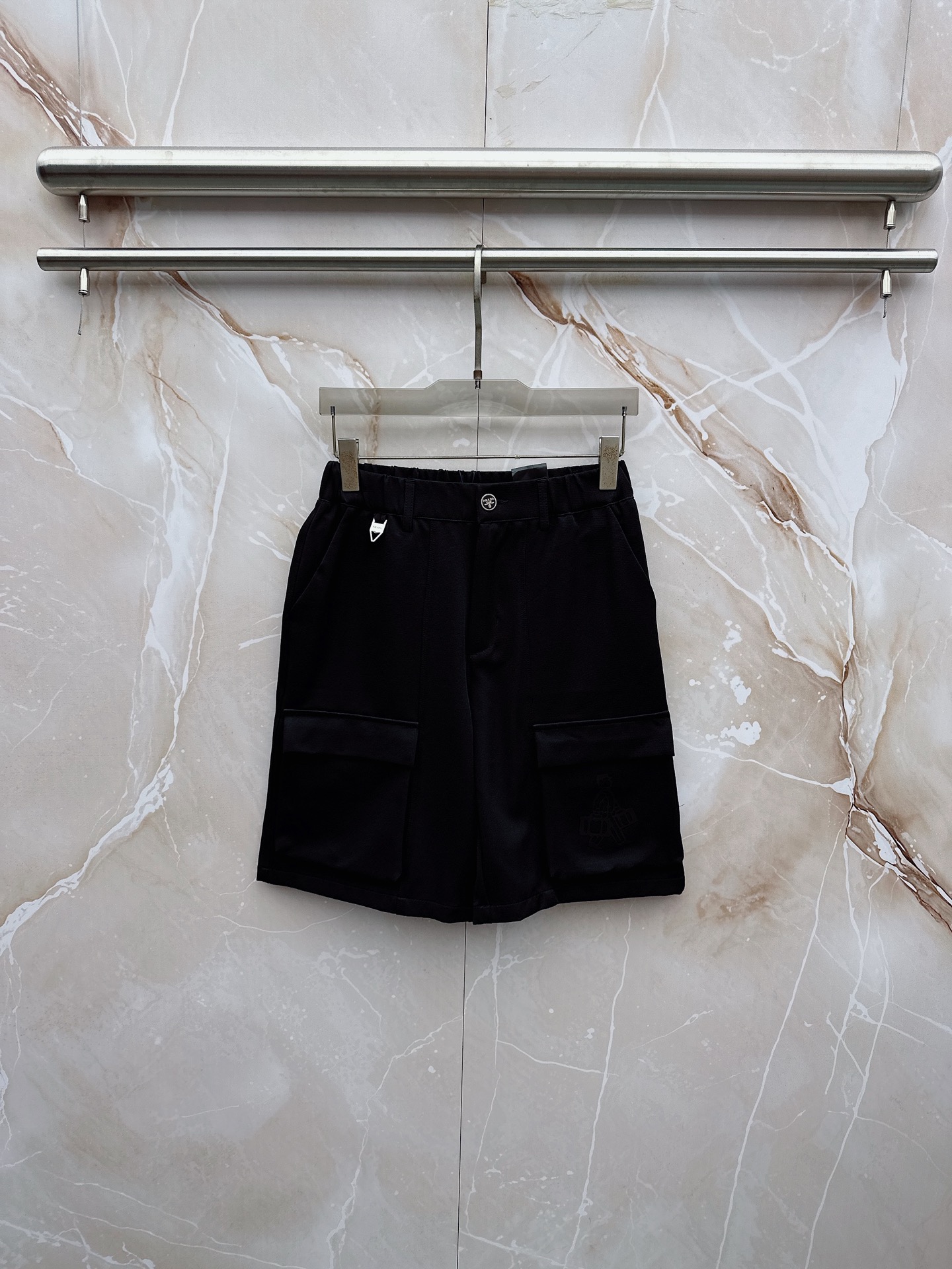 NO:932796,Prada 2026 spring and summer new cargo shorts continue the classic Cargo  Pocket design, two-dimensional three-dimensional large pockets on both sides combine practicality and style. The drawstring elastic waistband adapts to various body shapes and easily creates a casual street posture. The fabric is made of light and breathable cotton blend material, which is soft and skin-friendly, suitable for spring and summer.  It is refreshing and not stuffy to wear, and the drapey fabric naturally modifies the shape of the legs, giving it a lazy atmosphere when walking. The details are embellished with metal buttons and exquisite brand logos, highlighting quality in a low-key manner. The overall style combines the tough lines of Japanese workwear with American style  They have a casual and relaxed feel, with neat silhouettes for outdoor functions, but without losing the trendy attitude of urban streets. Whether it is daily commuting, weekend outings or sports and fitness, they can be easily controlled and show effortless fashion. In the spring and summer of 2026, make these cargo shorts a versatile tool in your wardrobe. It uses simple colors and practical designs to interpret the new generation of street aesthetics, and easily wears the perfect balance of high-end and comfort. M-3XL,, prada, shorts,19860909普拉达 2026春夏新品工装短裤,延续经典Cargo Pocket设计,双侧立体大口袋兼具实用性与造型感,抽绳松紧腰头适配各种身形,轻松打造随性街头姿态.面料选用轻薄透气的棉质混纺材质,触感柔软亲肤,春夏穿着清爽不闷热,垂坠感十足的面料自然修饰腿型,走动间自带慵懒氛围.细节处点缀金属纽扣与精致品牌标识,低调中彰显品质.整体风格融合日系工装的硬朗线条与美式休闲的松弛感,既有户外机能的利落轮廓,又不失都市街头的潮流态度.无论是日常通勤、周末出游还是运动健身,都能轻松驾驭,展现不费力的时髦感.2026春夏,让这条工装短裤成为你衣橱里的百搭利器,用简约色彩与实用设计诠释新一代街头美学,轻松穿出高级感与舒适度的完美平衡.M-3XL,,prada,shorts,,Men's clothing