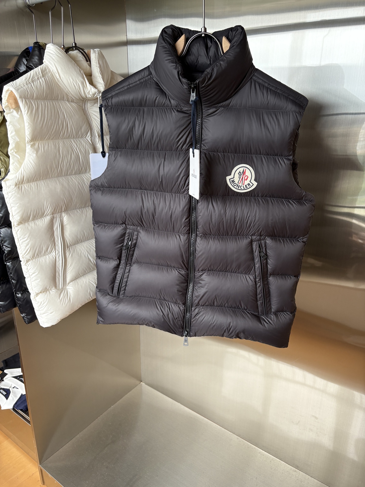 NO:529879,Top version MONCLER 2025 latest Mon*ler Gien series vest vest classic Gien series is the best style that Mon must be released every year. The counter is sold simultaneously, warm, light, comfortable and casual. As a representative figure in the down industry in autumn and winter, Mon has a classic that never gives up, and its glorious history belongs to its supreme glory! The design inherits the same classic cutting design as before. The down vest vest vest uses high-density polyester amine fiber exterior material, which is the Toray 12D painted nylon fabric imported from Japan. This fabric feels extremely smooth and comfortable without roughness, bright and bright color, windproof, cold and resistant to diamond undies. 90 white duck down, extremely warm, light and breathable, fluffy and full without any odor! The chest is equipped with the exclusive logo of Mon's embroidered felt craft that has always been adhered to.  The seasonal design is upgraded and updated every year. The classic three-color wavy fine webbing with a double-layer national flag on the side is different from the old models in previous years. The precious and thick hardware details reflect the extraordinary identity of this product. The double-headed zipper design also reflects the full sense of modern fashion. The new color striped placket design elements reflect the rich artistic atmosphere of Mon, and various signs indicate its value and significance. A must-have model for everyone to use! Color black Size 1-2-3-4-5 (M~3xl), Moncler, down jacket, alexander wang19860909顶级版本 MONCLER 蒙口 2025最新款Mon*ler Gien系列背心马甲 经典的Gien系列每年Mon必出的精品款式.柜台同步发售,保暖轻盈舒适休闲.Mon做为秋冬季节羽绒行业的代表人物拥有永不言败的经典,辉煌历史属于它至高无上荣耀! 设计上继承了以往一样的经典裁剪设计.羽绒马甲背心,运用了高密聚脂胺纤维外料也就是日本进口的东丽12D漆面尼龙面料.此等面料手感极为顺滑舒适无粗糙感,色泽光亮艳丽且防风抗寒抗钻绒. 90白鸭绒,保暖性极强,轻便透气,蓬松饱满且无任何异味!胸前配备了一贯坚持的刺绣毛毡工艺Mon的专属标志. 时节性的设计每一年都升级更新改造.侧身添加了双层国旗的经典三色波浪纹细织带装饰区别于往年的老款.珍贵厚实五金细节体现此款产品不一般的身份.双头拉链设计也体现了十足的现代时尚感.新型彩条纹的门襟设计元素体现出Mon的艺术气息浓郁,种种迹象表明它的价值意义.呼吁人手一件的必备款! 颜色黑色 尺码1-2-3-4-5（M～3xl）,,Moncler,down jacket,alexander wang,Men's clothing