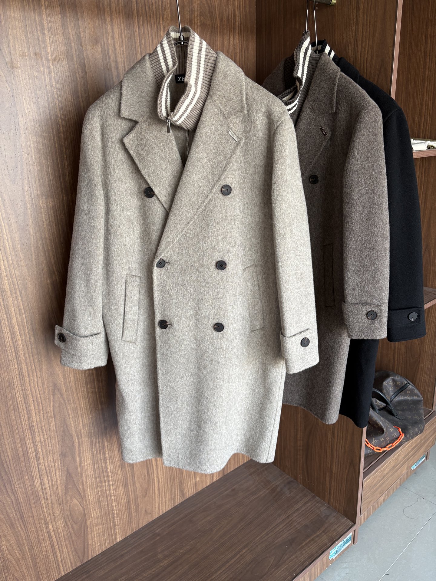 NO:690654,Jeni 25FW new autumn and winter wool coat, wool coat interprets the elegance and warmth of winter] The winter wind brings biting and chill, but it also brings fashion opportunities. When the classic herringbone pattern meets wool fabric, a unique coat emerges, adding an irresistible charm to your winter outfit.  With the herringbone texture as the design highlight, the unique pattern seems to tell the story of the years, adding a retro and literary atmosphere to the overall look. Its style is simple yet grand, and the smooth lines outline an elegant outline. Whether it is worn open to show casualness, or buttoned up to create a neat look, it can easily control various styles.  What’s even more surprising is that this coat can be worn with a stand-up collar. The stand-up collar design can not only provide warm protection for your neck in the cold wind, but also instantly enhance your aura and make you stand out from the crowd. When the cold wind blows, stand the collar high, as if you are building a warm barrier for yourself, while still maintaining a sense of fashion.  The choice of fabric is the essence of this coat. The blend of wool and cashmere combines the stiffness of wool with the softness of cashmere. Wool gives the coat good support and warmth, making it able to withstand the severe cold of winter; while the addition of cashmere makes the coat more delicate and skin-friendly to the touch, as if it is wrapped in a layer of soft clouds. This blended fabric is not only comfortable to wear, but also has a high-quality texture, showing a high-quality style.  In terms of color, we have carefully blended two classic tones, dark gray and light coffee. Dark gray is calm and restrained, suitable for you who pursue low-key luxury; light coffee is warm and soft, adding a warm color to winter. No matter what style lover you are, you can find your favorite choice in these two colors. Size M-3XL,,zegna,19860909杰尼25FW秋冬新款羊毛大衣,羊毛大衣演绎冬日的优雅与温暖】冬日的风,带着凛冽与寒意,却也吹来了时尚的契机.当经典的人字纹邂逅羊毛面料,一件别具一格的大衣应运而生,为你的冬日穿搭增添一抹难以抗拒的魅力. 以人字纹理为设计亮点,独特的纹路仿佛在诉说着岁月的故事,为整体造型增添了复古与文艺的气息.它的款式外形简约而不失大气,流畅的线条勾勒出优雅的轮廓,无论是敞开穿展现随性,还是系上扣子塑造利落感,都能轻松驾驭各种风格. 更令人惊喜的是,这款大衣可以实现立领的穿搭方式.立领的设计不仅能在寒风中为你的脖颈提供温暖的守护,还能瞬间提升气场,让你在人群中脱颖而出.当寒风乍起,将领子高高立起,仿佛为自己筑起一道温暖的屏障,同时又不失时尚感. 而面料的选择,更是这款大衣的精髓所在.羊毛与山羊绒的混纺,兼具了羊毛的挺括与山羊绒的柔软.羊毛赋予了大衣良好的支撑性和保暖性,使其能够抵御冬日的严寒；而山羊绒的加入,则让大衣在触感上更加细腻亲肤,仿佛被一层轻柔的云朵包裹.这种混纺面料不仅穿着舒适,而且质感上乘,彰显出高品质的格调. 在色彩上,我们精心调配了深灰与浅咖两种经典色调.深灰,沉稳内敛,适合追求低调奢华的你；浅咖,温暖柔和,为冬日增添一抹温馨的色彩.无论你是哪种风格爱好者,都能在这两款颜色中找到属于自己的心仪之选. 码数M-3XL,,zegna,,Men's clothing