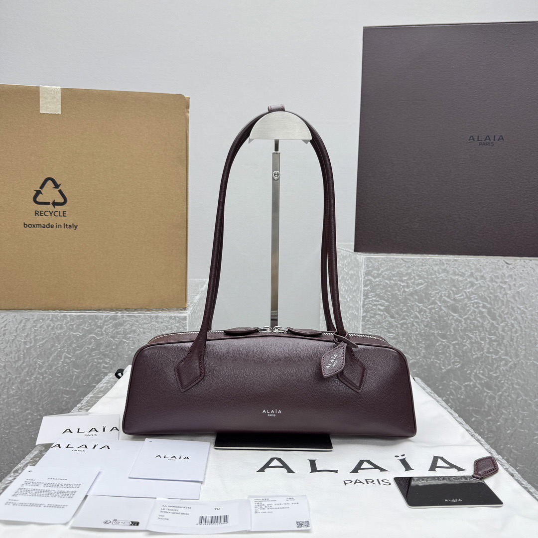 NO:552594,Large {full leather burgundy} top version, all-steel hardware + thick-cut mirror + riri two-way puller I New E TEKE Sausage Bag | Underarm Bag Recently, Alaia’s new Le Teckel underarm bag has really hit the screens, it’s so popular!  The design of the long-handled baguette bag is full of retro fashion. Because the design is inspired by the designer's favorite dachshund dog, this bag is also called the 'dachshund dog bag'~ The flat and long bag shape is very fashionable and recognizable. The long shoulder strap is not just stuck under the arm, but leaves room for it, giving it a French casual feel. There are two sizes to choose from, and it is expected to become a big hit this season. The small size has a base length of 27 x height 8 x width 9cm.  Large size bottom length 33x height 10x width 11cm, DG, alaia19860909大号｛全皮酒红色｝顶级版,全钢五金+厚切镜子+riri双向拉头 I 新款E TEKE腊肠包｜腋下包 最近真的被 Alaia 的新款Le Teckel腋下包刷屏,实在太火了！长柄法棍包的设计复古时髦感拉满,因为设计灵感来源于设计师钟爱的腊肠狗为原型,所以这只又被称为“腊肠狗包”~扁长包型极具时尚辨识度,长长的肩带的设计,不是刚好卡在腋下,而是留有余地,就很有法式的随意感,有两个 size 可选,预计又会成为本季的大爆款 小号尺寸底长27x高8x宽9cm 大号尺寸底长33x高10x宽11cm,DG,alaia,Bag