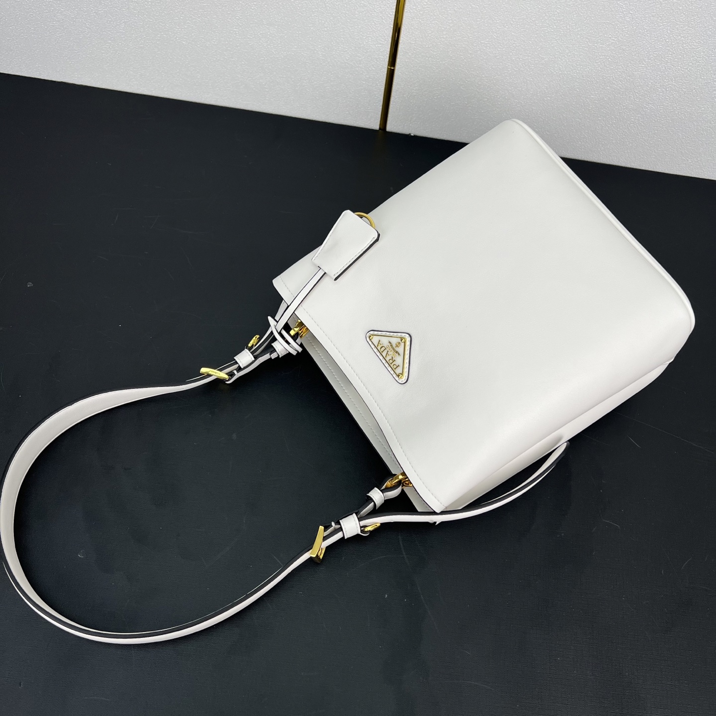 🎉新品🎉1BE080水桶包🎉P这款皮革手袋拥有柔和线条与精美设计，凸显经典格调与手工细节。实用百搭，饰有
