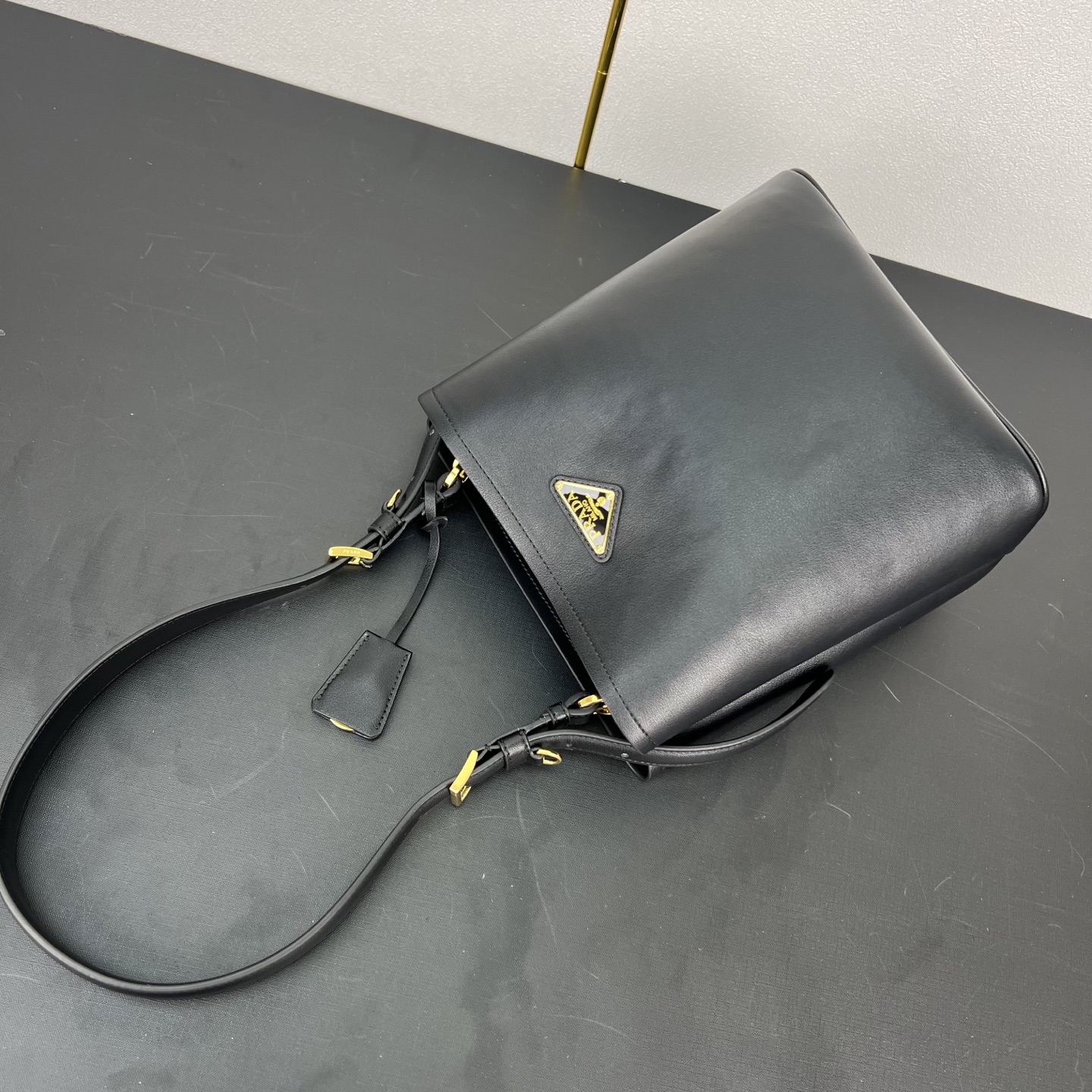 🎉新品🎉1BE080水桶包🎉P这款皮革手袋拥有柔和线条与精美设计，凸显经典格调与手工细节。实用百搭，饰有