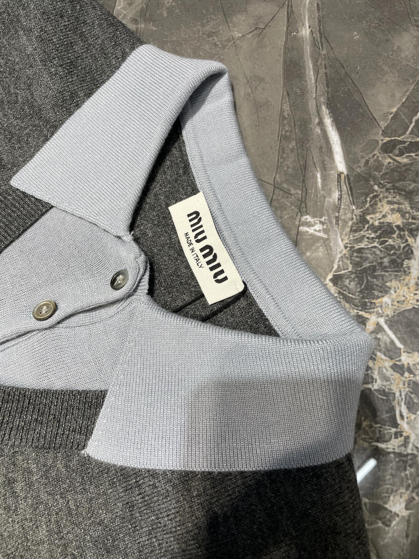 💰238 Miu Miu 25Fw 🌟

拼色领毛衣
面料精选亲肤天丝+精选羊毛+光泽真丝三重质感，大身使用28支双股羊毛材质12针机器，领子下摆袖口采用真丝16针斯托尔横机针织精密针织而成真丝部分触感丝滑亲肤提升了整体奢华感和舒适感同时保证了边缘挺括有型，胸前字母LOGO嵌花工艺立体有型，灰调拼色运用「无缝引返编织」工艺，拼色接缝平整，整体做工细致，双领结构打破常规，外显慵懒内藏精致，男女同款

size：38 40 42