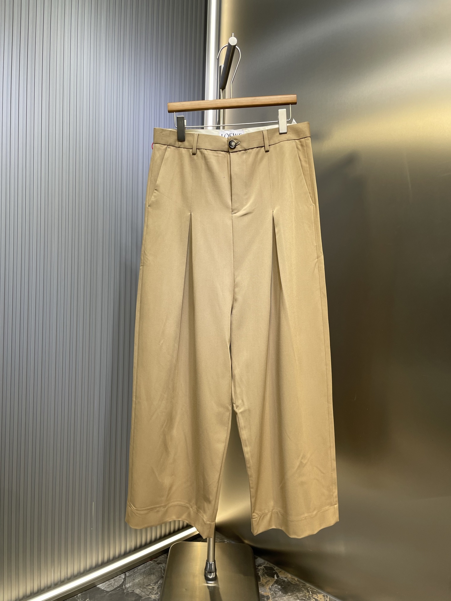 NO:528264,Loewe buckle wide-leg trousers Customized tight cotton twill worsted material, smooth draping, delicate and breathable, with pure black as the background, calm and atmospheric, carefully crafted pleats in front are three-dimensional, with a sense of rhythm between the ups and downs. Loewe engraved buckles as the finishing touch, like a work of art, a concise symbol of the brand spirit, exudes a low-key and luxurious light In the name of design, engraving fashion legends Craft 1: Peak trace three-dimensional double pleats Fold according to the double pleat structure Form the prototype of pleats Use hidden needle method and combined with special adhesive to fix the pleats on the surface of the trousers to create a clear three-dimensional undulation effect. The edges are finely processed, and the lines are straight and regular. Craft 2: The trousers’ legs are used to make no marks and pick the feet. The key technology to realize invisible sewing of trousers’ legs in sewing. Through fine needle method, tool selection  Make the edges of the trouser legs flat and beautiful without exposed stitches. Use an iron to gently iron the edges of the trouser legs again. Craft 3: The fabrics are washed with filial piety. The texture is better. It is not easy to deform. It is not easy to shrink. It is not easy to fade. It maintains long-term beauty. Accessories. Customized 1:1 Loewe buckle. Customized 1:1 Loewe horn buckle. Customized 1:1 Loewe hanging bell. Customized 1:1 Loewe leather card. Customized 1:1 Loewe leather strip. Customized 1:1 Loewe zipper. Customized 1:1 Loewe trademark. Combined loose fit. Size 46 48 50 52,,loewe,alexander wang.19860909Loewe 搭扣阔腿长裤 定制紧致棉质斜纹精纺料 垂感爽滑 细腻透气 以纯粹之黑为底色 沉稳大气 前幅精心打造的褶裥呈三维形态 起伏之间带着一种韵律感 侧面Loewe镌刻搭扣作点睛之笔 宛如一件艺术品 是品牌精神的凝练象征 散发着低调而奢华的光芒 以设计之名 镌刻时尚传奇 工艺1: 峰迹立体双褶 按照双褶结构进行折叠 形成褶裥的雏形使用隐蔽的针法以及结合特殊的粘合剂将褶裥固定 在裤子表面塑造出明显的立体起伏效果 边缘处理精细 线条笔直且规整 工艺2: 裤脚口做无痕挑脚 缝纫中实现裤脚隐形缝制的关键技术 通过精细的针法 工具选择 使裤脚边缘平整美观且无外露线迹 再二次用熨斗轻轻熨烫裤脚边缘 工艺3: 面料都经过孝洗 手感质感更佳 不易变形 不易缩水 不易褪色 保持长久的美观 辅料 定制1:1 Loewe 搭扣 定制1:1 Loewe 牛角扣 定制1:1 Loewe 吊钟 定制1:1 Loewe 皮牌 定制1:1 Loewe 皮条 定制1:1 Loewe 拉链 定制1:1 Loewe 商标 版型 宽松版型 尺码 46 48 50 52,,loewe,alexander wang,Men's clothing