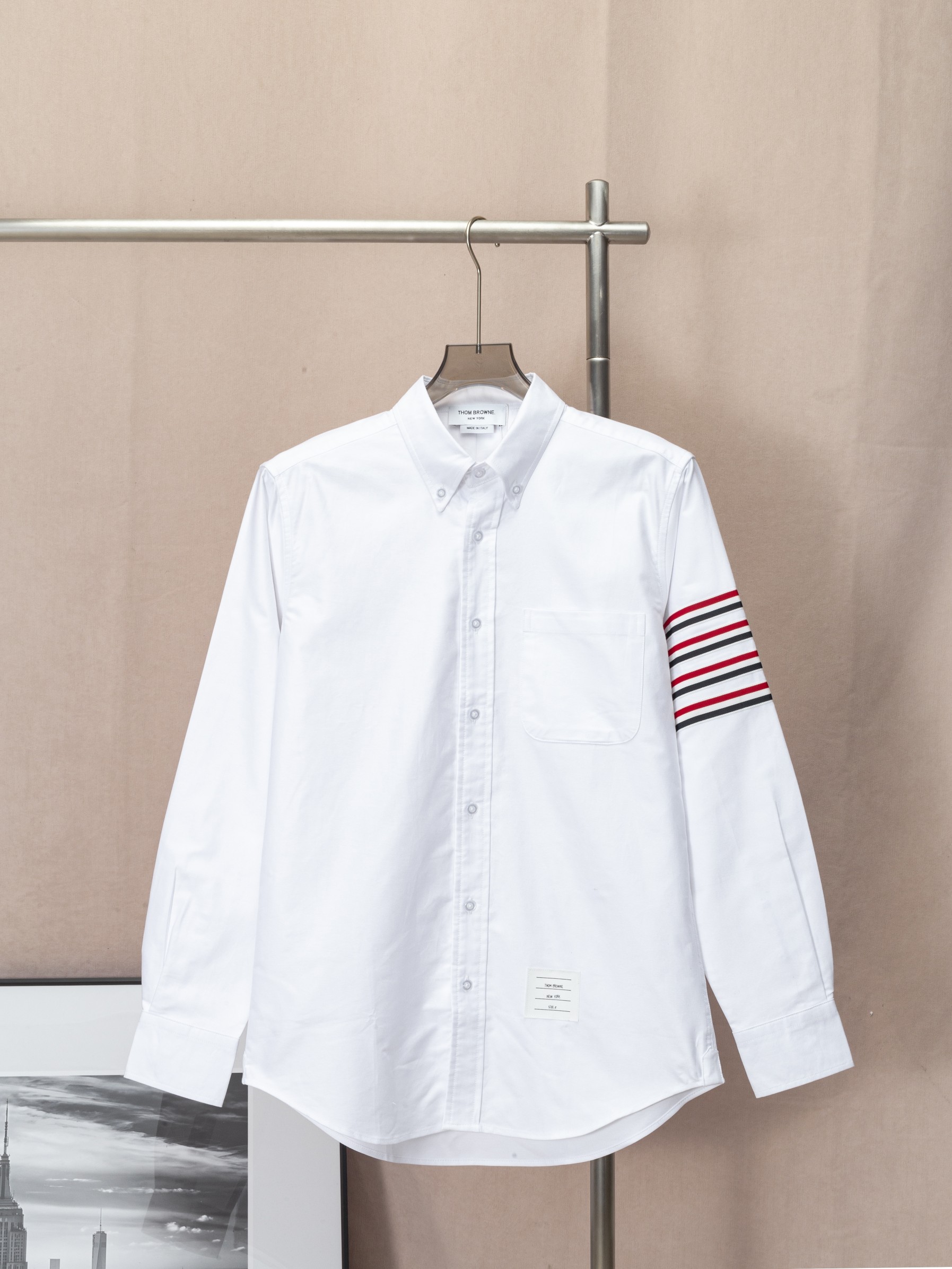 (Camisa TB con cuatro rayas y cinta roja, blanca y azul en las mangas, en stock) THOM BROWNE, sincronizado con la tiend…