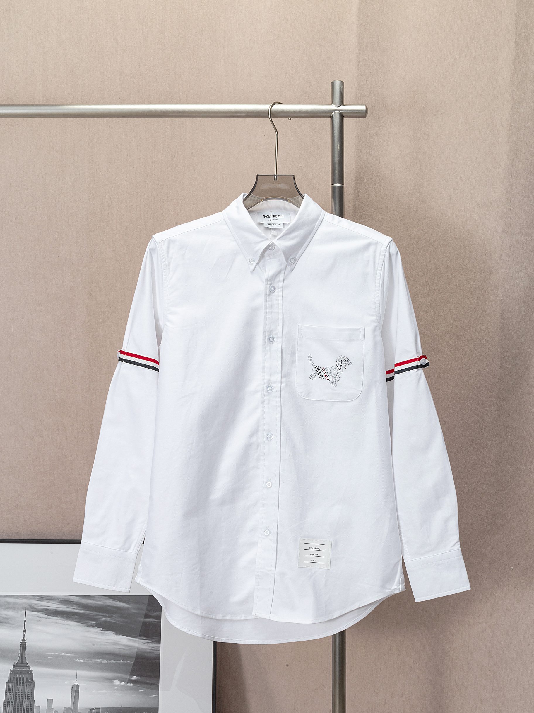 (Camisa TB con bolsillo y perrito de pedrería termoadhesiva, mangas con cinta, en stock) THOM BROWNE, sincronizado con …