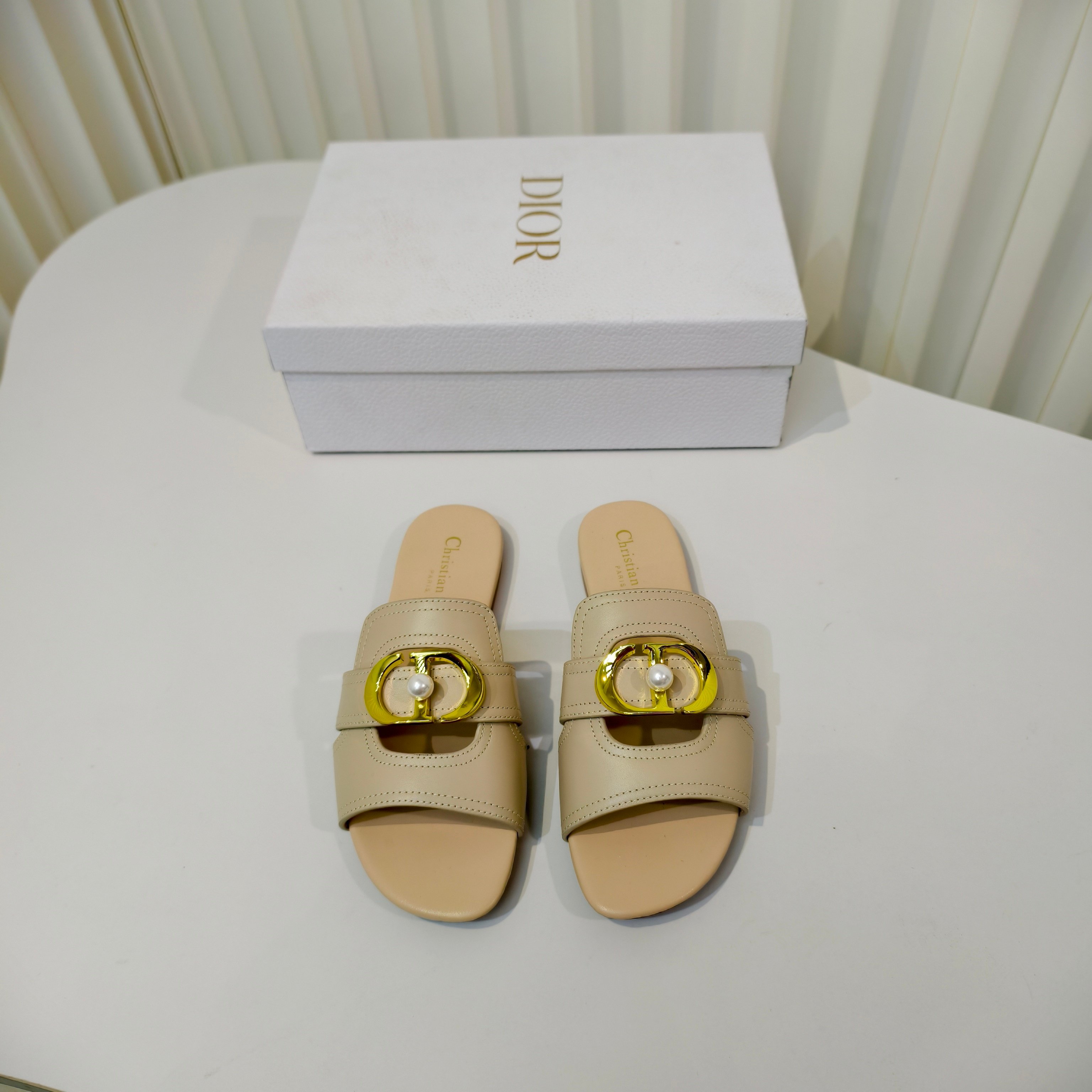 NO:651887,Dior's 2026 spring new style is available in advance. This C'est Dior low-heeled sandal is elegant and fashionable. The upper is carefully made of cowhide, simple and elegant. It is decorated with gold-finished metal C and D letters to enhance the style. It is decorated with white pearls in the middle and is inspired by the Dior archives. The design is elegant. The square toe and flat heel complement each other, making the fashionable shape more refined and adding elegance to various looks. The outsole is made of Italian imported genuine leather.  Size34-43 (34.40.41.42.43 customized sizes are non-refundable and non-exchangeable), slippers, dior, slippers, cowhide, Leather soles19860909Dior 2026春季新款提先上啦这款 C ' est Dior 低跟凉拖优雅时尚,鞋面采用牛皮精心制作,简约雅致,饰以金色饰面金属 C 和 D 字母提升格调,中间搭配白色珍珠加以修饰,灵感源自 Dior 档案.设计优雅,方形鞋头与平跟相得益彰,令时尚的造型更加精致,可为各式造型增添高雅气质,大底采用意大利进口真皮大底 Size34-43码（34.40.41.42.43定做码数不退不换）,拖鞋,dior,slippers,cowhide,Leather soles,Women's Shoes