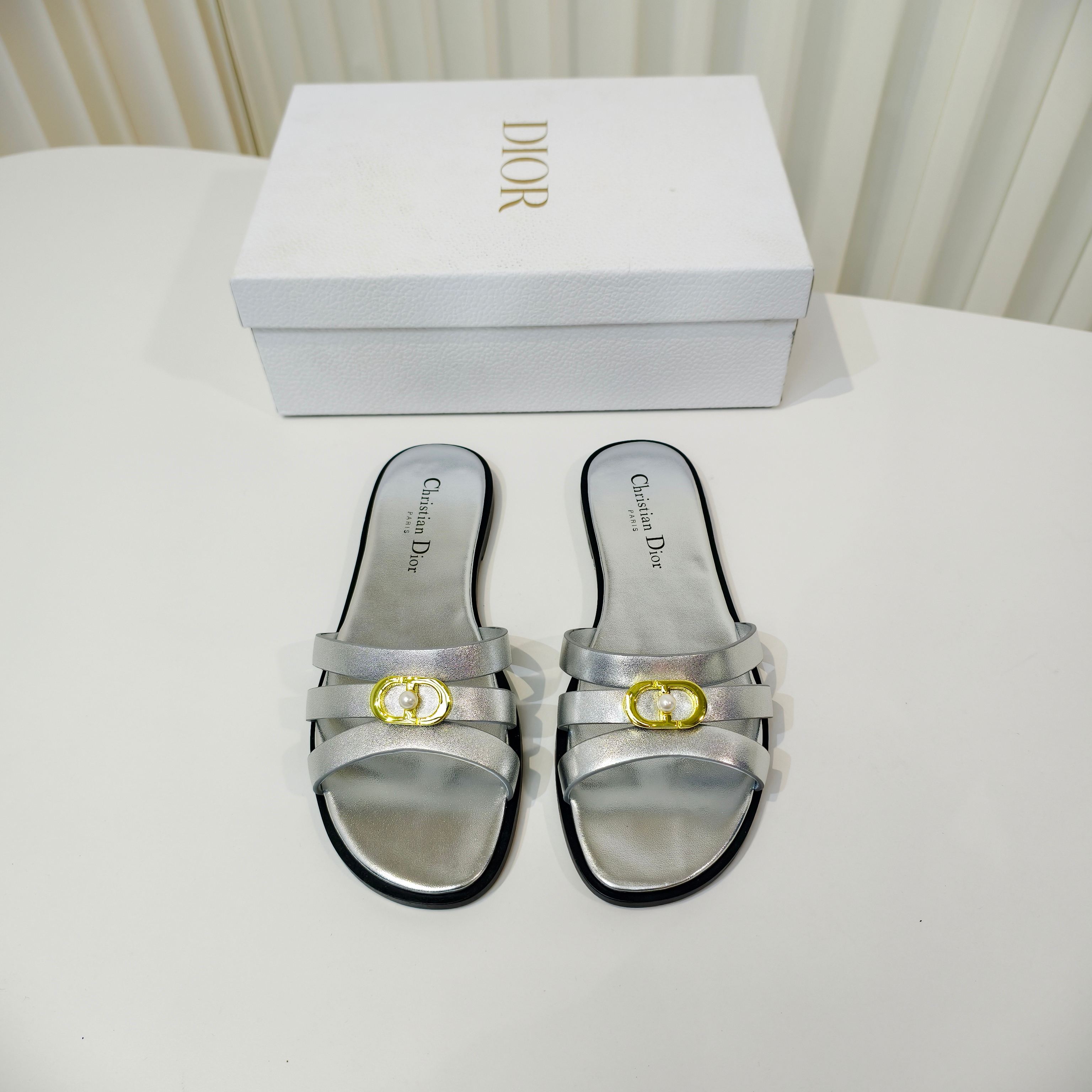 NO:651897,Dior's 2026 spring new style is available in advance. This C'est Dior low-heeled sandal is elegant and fashionable. The upper is carefully made of cowhide, simple and elegant. It is decorated with gold-finished metal C and D letters to enhance the style. It is decorated with white pearls in the middle and is inspired by the Dior archives. The design is elegant. The square toe and flat heel complement each other, making the fashionable shape more refined and adding elegance to various looks. The outsole is made of Italian imported genuine leather.  Size34-43 (34.40.41.42.43 customized sizes are non-refundable and non-exchangeable), slippers, dior, slippers, cowhide, Leather soles19860909Dior 2026春季新款提先上啦这款 C ' est Dior 低跟凉拖优雅时尚,鞋面采用牛皮精心制作,简约雅致,饰以金色饰面金属 C 和 D 字母提升格调,中间搭配白色珍珠加以修饰,灵感源自 Dior 档案.设计优雅,方形鞋头与平跟相得益彰,令时尚的造型更加精致,可为各式造型增添高雅气质,大底采用意大利进口真皮大底 Size34-43码（34.40.41.42.43定做码数不退不换）,拖鞋,dior,slippers,cowhide,Leather soles,Women's Shoes