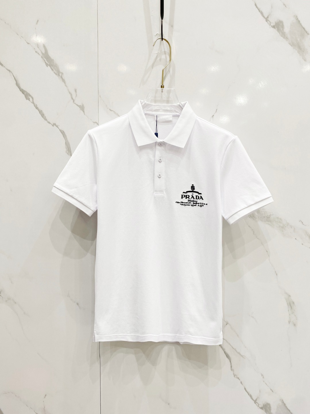 NO:135454,Prada 2025ss summer new logo men's lapel Polo shirt!  Classic business men's style, high-end men's style at the ceiling level of business men's style!  Simple, fashionable and elegant, single-wearing inner wear is decent, quality control/detail control takes away, low-key, luxurious and connotative!  Customer-supplied fixed mesh flooring cotton cloth is carefully made, the surface of the fabric is evenly arranged and neatly arranged, with excellent breathability and heat dissipation and sweat resistance, and the comfort level of the upper body is completely better than that of ordinary single-sided sweat cloth tissue!  The brand LOGO logo with classic hem is created with top-level craftsmanship. The LOGO has three-dimensional, clear and full texture, and is an extraordinary product in the classic field whether it is inner wear or single wear!  The exquisite cutting process, the processing of every detail is very standard and delicate, and it is comparable to that of ordinary LOW products on the market. Men must enter the basic versatile Polo shirts!  Color black white Size M-3XL Data reference M: bust 104cm-shoulder width 45cm-coat length 69cm-sleeve length 21cm L: bust 108cm-shoulder width 46cm-coat length 70cm-sleeve length 22cm XL: bust 112cm-shoulder width 47cm-coat length 71cm-sleeve length 23cm XXL: bust 116cm-shoulder width 48cm-coat length 72cm-sleeve length 24cm 3XL: bust 120cm-shoulder width 49cm-sleeve length 73cm-sleeve length 24cm AAA5,,prada,alexander wang19860909普拉达 2025ss夏季新款 logo男士翻领Polo衫！经典商务男款,高端男装的天花板级别的商务男款！简约时尚大气不失优雅,单穿内搭体面过人,品质控/细节控的闭眼带走,低调又奢华有内涵！ 客供定织网眼珠地棉布精心制成,面料表面排列均匀整齐的网眼纹理,透气性和散热排汗性极佳,上身舒适程度完全优于普通单面汗布组织！下摆经典的品牌LOGO标识,采用顶级工艺打造,LOGO立体清晰饱满,质感非凡的特质,无论是内搭还是单穿都是一款经典领域的产品！精妙绝伦的裁剪工艺,每一个细节处理的非常标准细腻,非市面一般LOW货可以媲美的,男士必入基础百搭款Polo衫推荐！ 颜色黑色 白色 尺码M-3XL 数据参考 M码:胸围104cm-肩宽45cm-衣长69cm-袖长21cm L码:胸围108cm-肩宽46cm-衣长70cm-袖长22cm XL码:胸围112cm-肩宽47cm-衣长71cm-袖长23cm XXL码:胸围116cm-肩宽48cm-衣长72cm-袖长24cm 3XL码:胸围120cm-肩宽49cm-衣长73cm-袖长24cm AAA5,,prada,alexander wang,Men's clothing