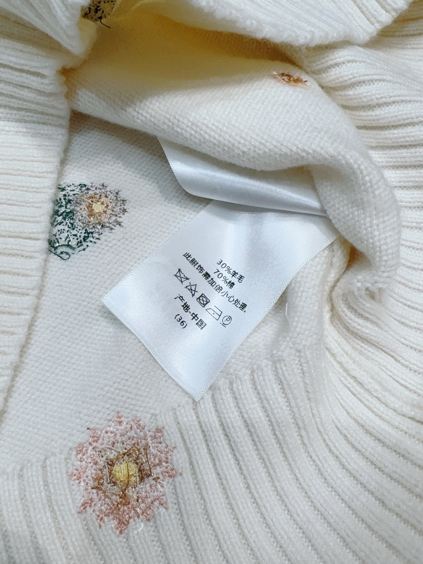 D家新品奶白色细针织短袖，软糯垂顺。衣身点缀手工彩色花卉与蜻蜓刺绣，中心水钻串珠字母精致闪耀，罗纹圆领与收边，版型利落不