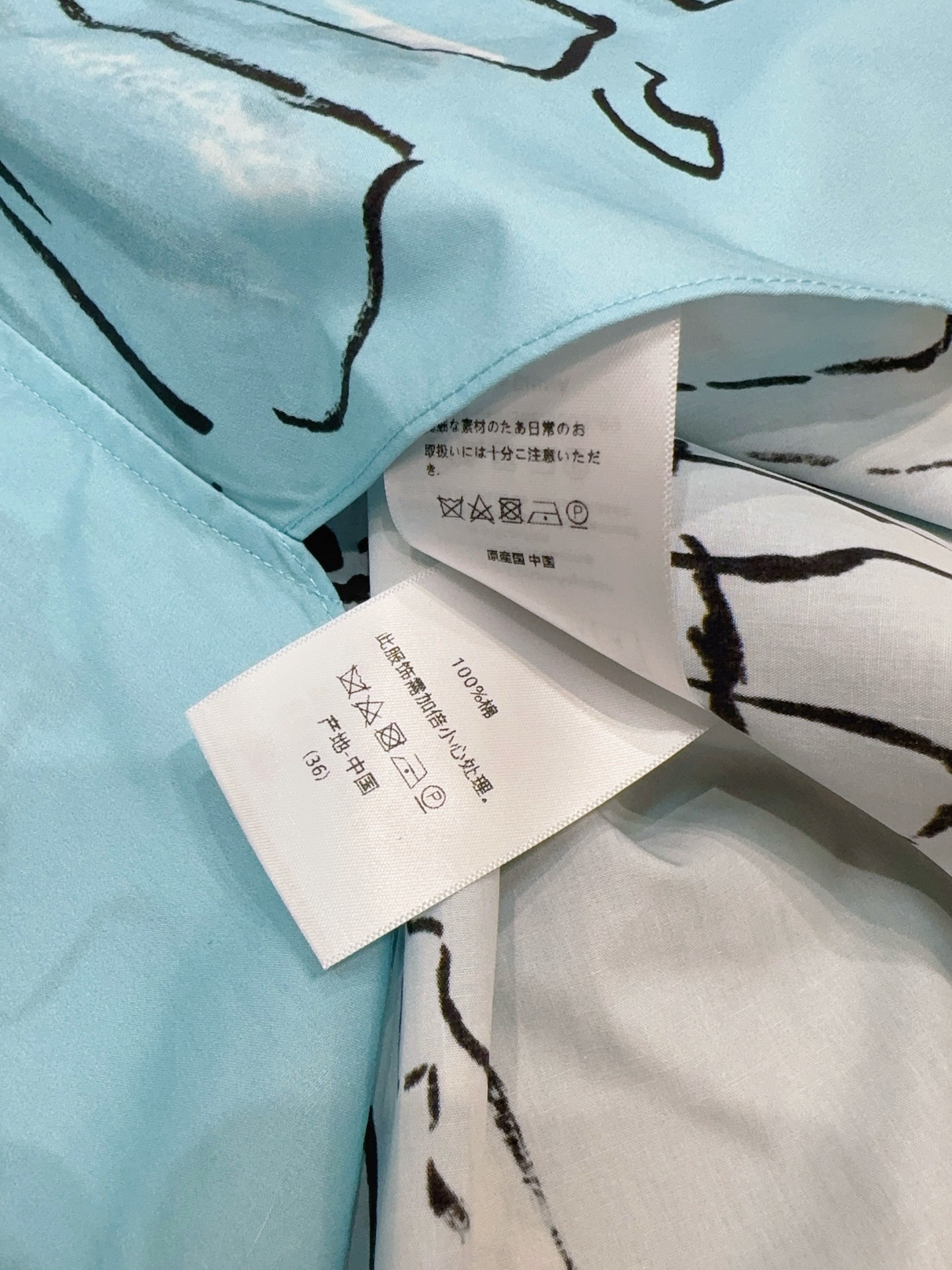 D家蓝色漫画立领短袖衬衫新品…… 中式小立领，门襟搭配细黑包边撞色线条，翻折短袖，袖口同样做黑色窄包边，利落显瘦，前短后