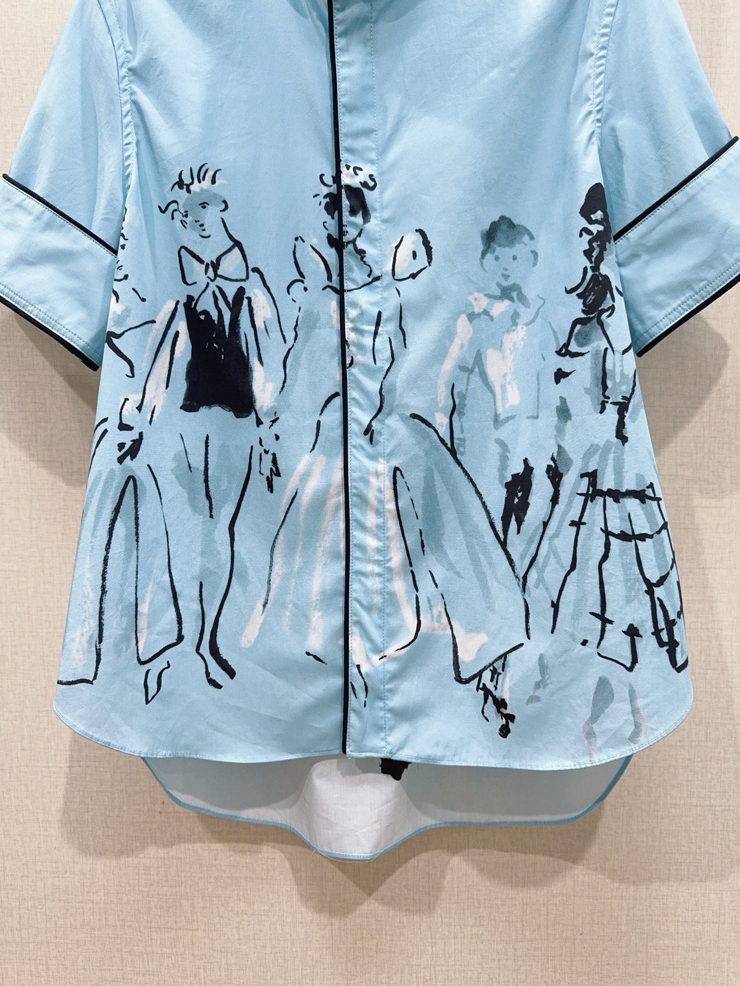 D家蓝色漫画立领短袖衬衫新品…… 中式小立领，门襟搭配细黑包边撞色线条，翻折短袖，袖口同样做黑色窄包边，利落显瘦，前短后
