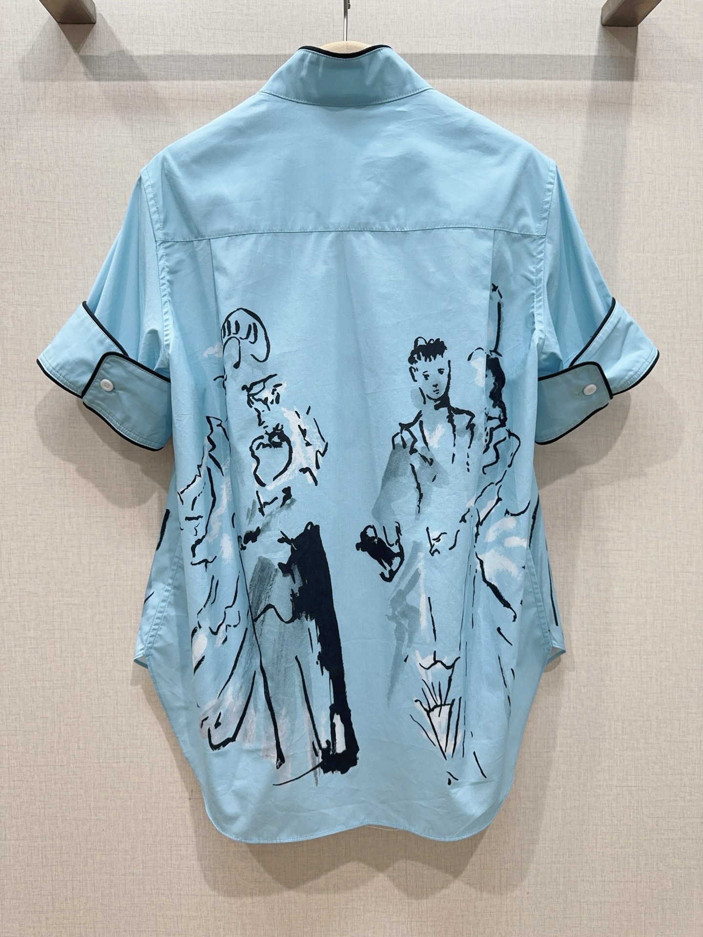 D家蓝色漫画立领短袖衬衫新品…… 中式小立领，门襟搭配细黑包边撞色线条，翻折短袖，袖口同样做黑色窄包边，利落显瘦，前短后