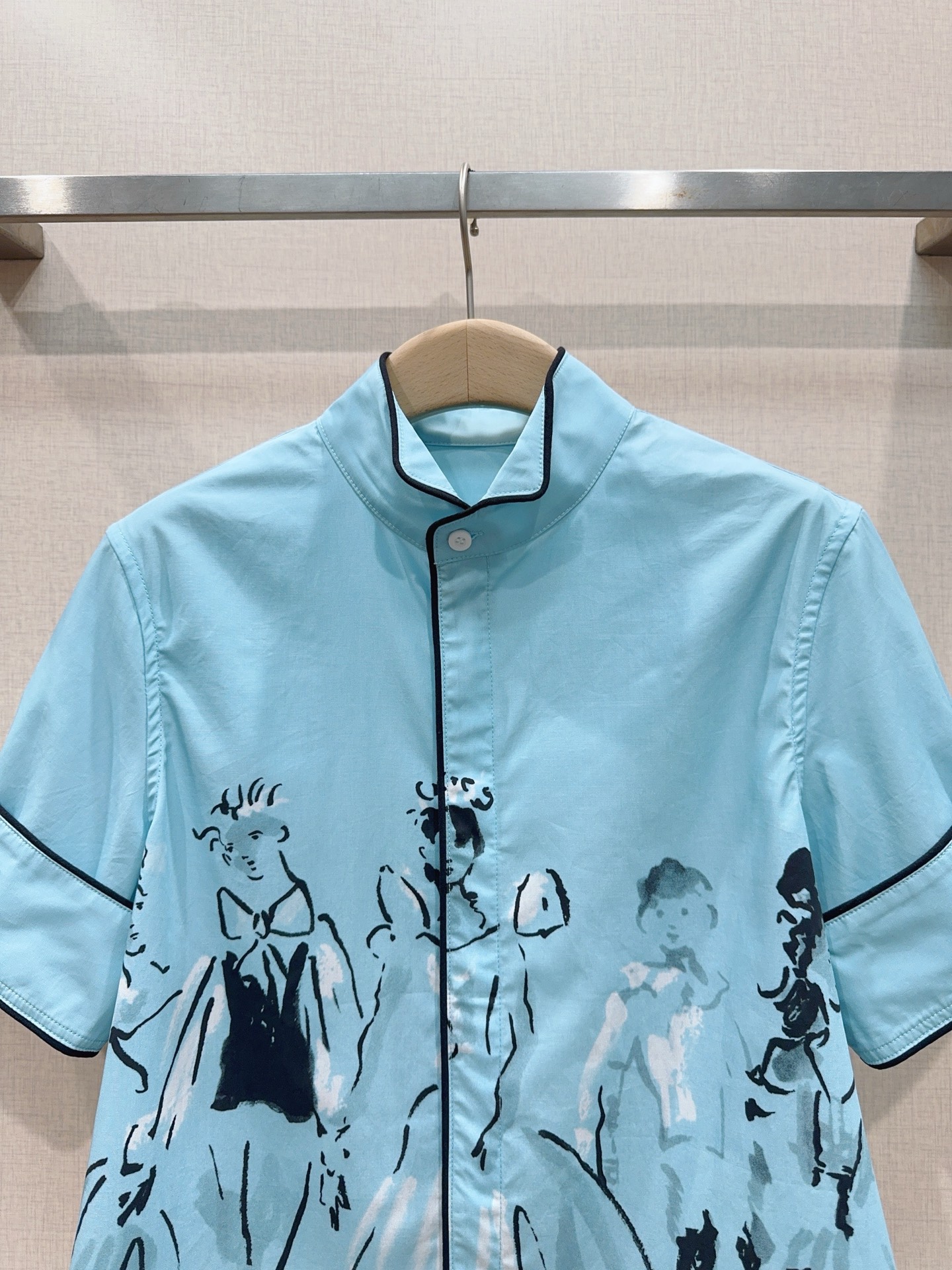 D家蓝色漫画立领短袖衬衫新品…… 中式小立领，门襟搭配细黑包边撞色线条，翻折短袖，袖口同样做黑色窄包边，利落显瘦，前短后