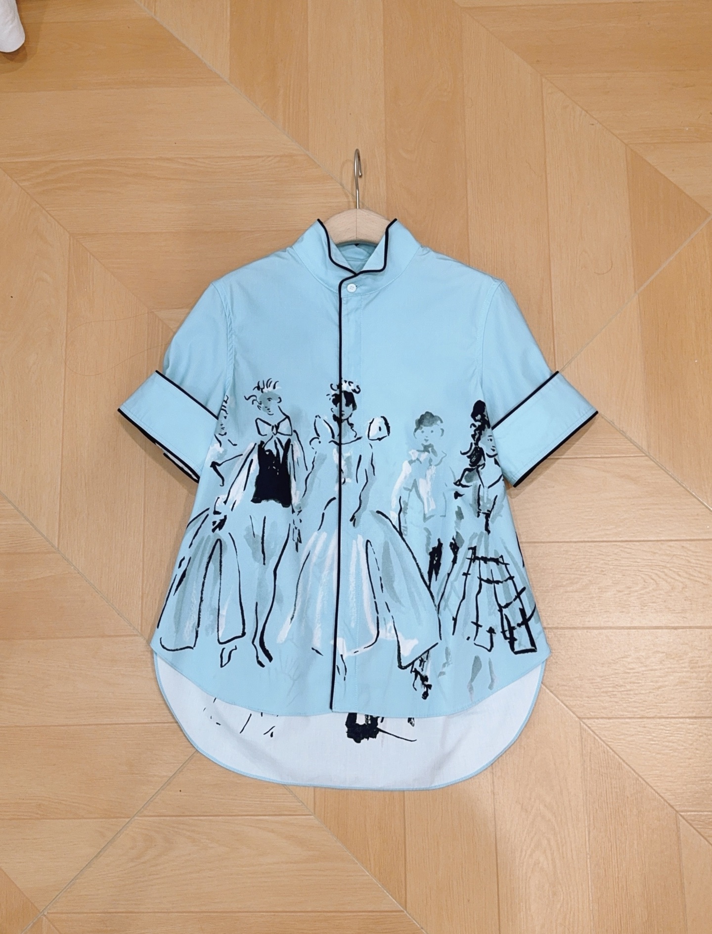 D家蓝色漫画立领短袖衬衫新品…… 中式小立领，门襟搭配细黑包边撞色线条，翻折短袖，袖口同样做黑色窄包边，利落显瘦，前短后