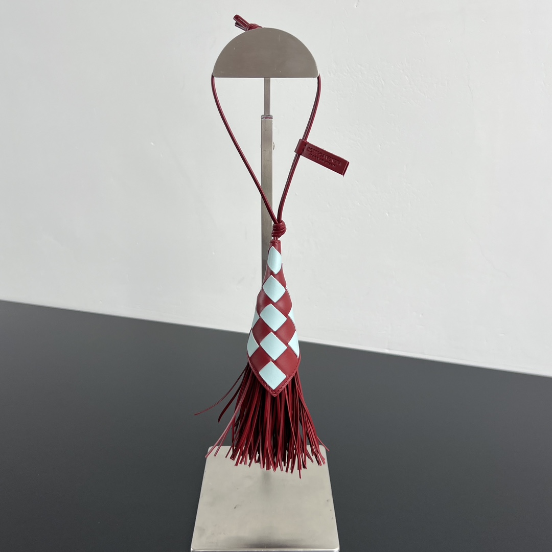 NO:617201,BV new tassel pendant 806221 Tired of the same bags?  You need a tassel pendant that can 'talk'. Burgundy + light blue. This smart color scheme instantly brightens up the dull sheep leather diamond plaid pattern, which is super textured!  The master uses abrasive tools to carefully cut the tassels, and the drape is just right. The closely connected tassels move with the rhythm of the body, and are elegant and sassy. It is not just an accessory. It is also the 'rhythm master' of your style. Size is 8cm high * 2cm wide, single piece jewelry     , bottega veneta, sheepskin19860909BV 新品流苏挂饰 806221厌倦了包包的千篇一律？你需要一条能“说话”的流苏挂饰酒红+浅蓝 这一抹灵动的配色,瞬间点亮沉闷羊皮革菱形格纹超有质感！经过师傅采用磨具细致裁剪流苏,垂坠感恰到好处,紧密相连的流苏,随着身体节奏律动,又A又飒,不只是一件配饰.更是你造型的“节奏大师” 尺寸高8*宽2cm,,单品首饰    ,bottega veneta,she,accessory