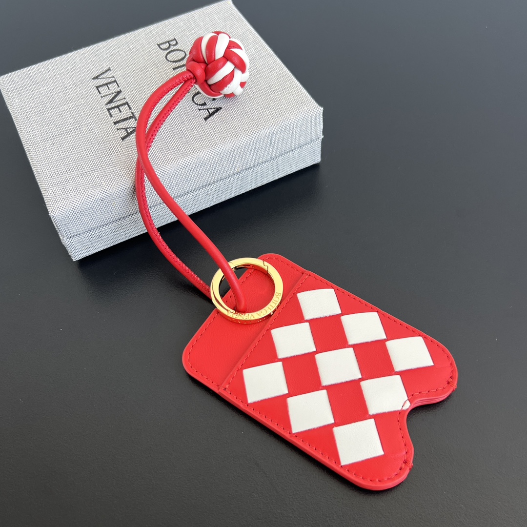 NO:617204,BV's new product woven pendant 796802 uses classic weaving technology and is made of red and white leather interlaced. The texture is delicate and full of three-dimensionality. It is lively and eye-catching yet elegant. The lanyard is equipped with a metal ring, which is convenient for hanging it on a bag or a keychain. There is a card slot inside, which can store a small amount of cards and is easy to carry and access. The brightly colored small pendant collides with the bag to create a different style. Hang it and immediately become unique.  Size 17*0.2, single jewelry    ,bottega veneta19860909BV新品 编织挂饰 796802 采用经典编织工艺,将红色和白色皮革交错编织而成,质感细腻且富有立体感即显活泼亮眼又不失优雅格调挂绳设有金属圆环,方便将其挂在包包,钥匙串～内里设有卡槽位置,可收纳少量卡片,便于携带和取用,颜色鲜艳小挂饰搭配包包碰撞出不同的风格,挂上它立马变得与众不同 尺寸17*0.2,单品首饰    ,bottega ,accessory