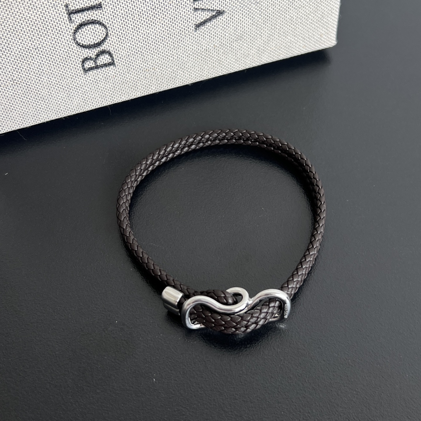 NO:854177,#BV New Product Unisex Braided Bracelet 829387 adopts the brand's signature weaving process, hand-woven double-strand sheepskin into a flexible rope strap. The knot buckle in the middle is the soul of the whole style. The double-ring shape is made of sterling silver. The silver metal and knot shape echo the core of the brand. It is unobtrusive but has high-end cold light. The magnetic closure design is both practical and neat, and the length of the bracelet can be adjusted at will.  Low-key but with a sense of high-end that makes people unable to take their eyes away, it hides unintentional sophistication in every moment when you raise your hand. Size 19cm P, BV, bottega veneta, bracelet, sheepskin, pure silver19860909#BV 新品 男女通用编织手链829387 采用品牌标志性编织工艺,将双股羊皮手工编织成柔韧的绳带,中间的绳结扣是整款的灵魂所在以纯银打造的双环造型,银色金属与绳结造型呼应品牌内核,不张扬却自带高级冷光♀磁吸式的闭合设计兼顾实用与利落,手绳长度可任意调节 低调却自带让人挪不开眼的高级感,把不刻意的精致藏在每一个抬手的瞬间 尺寸19cm P,BV,bottega veneta,bracelet,sheepskin,pure silver,欧美剧