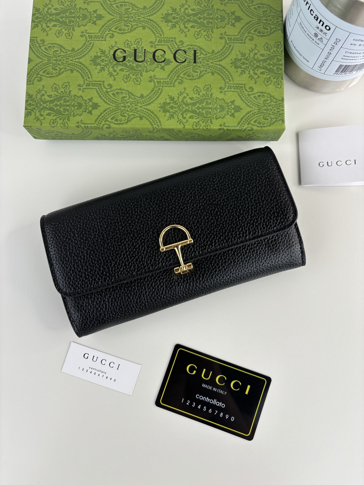 GUCCl 延续品牌深厚传承，深化与马术本源的联结。半马衔扣图案化身为开合细节，为多款小皮件增色添彩。这款长夹以黑色粒面