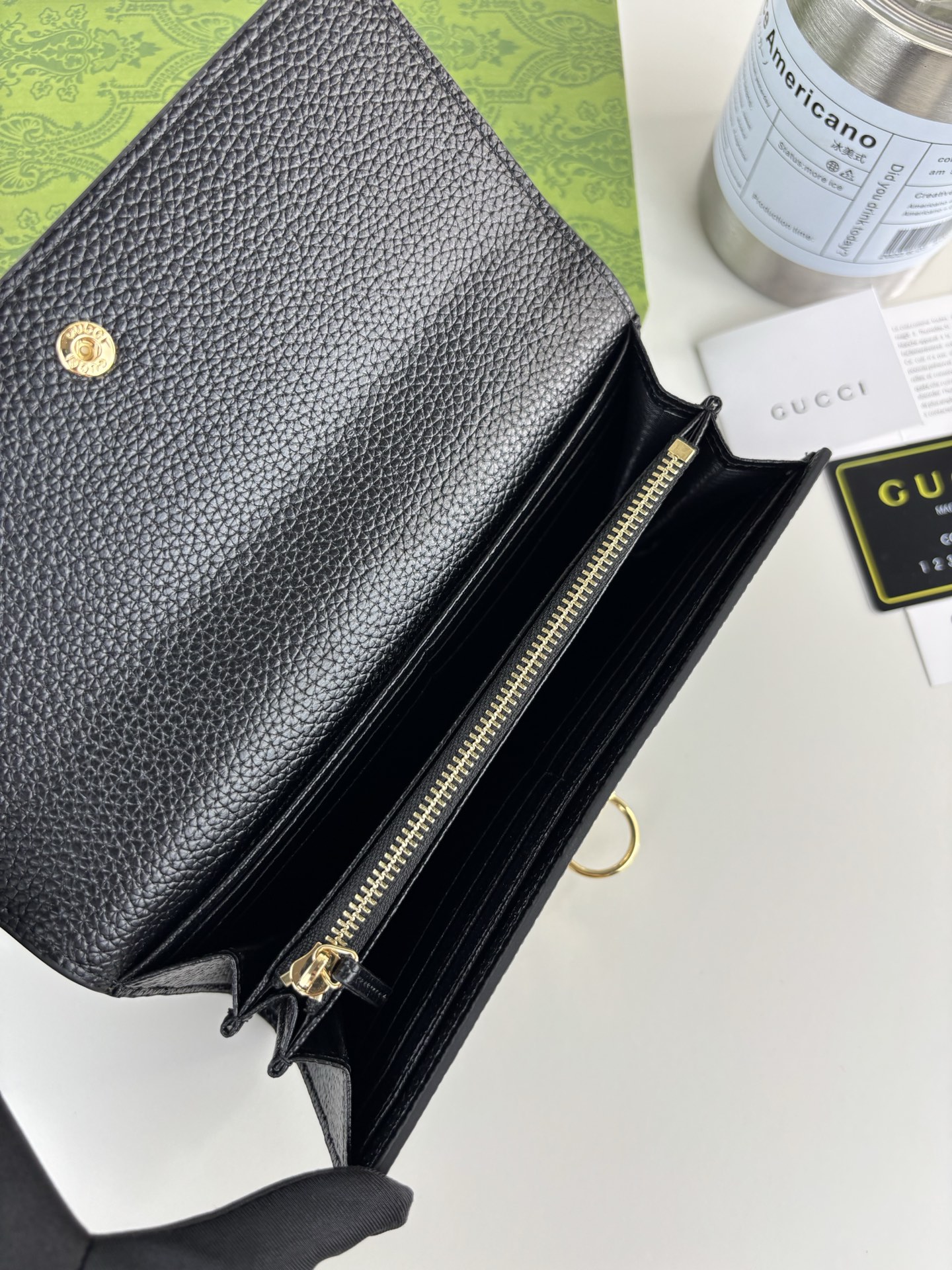 GUCCl 延续品牌深厚传承，深化与马术本源的联结。半马衔扣图案化身为开合细节，为多款小皮件增色添彩。这款长夹以黑色粒面