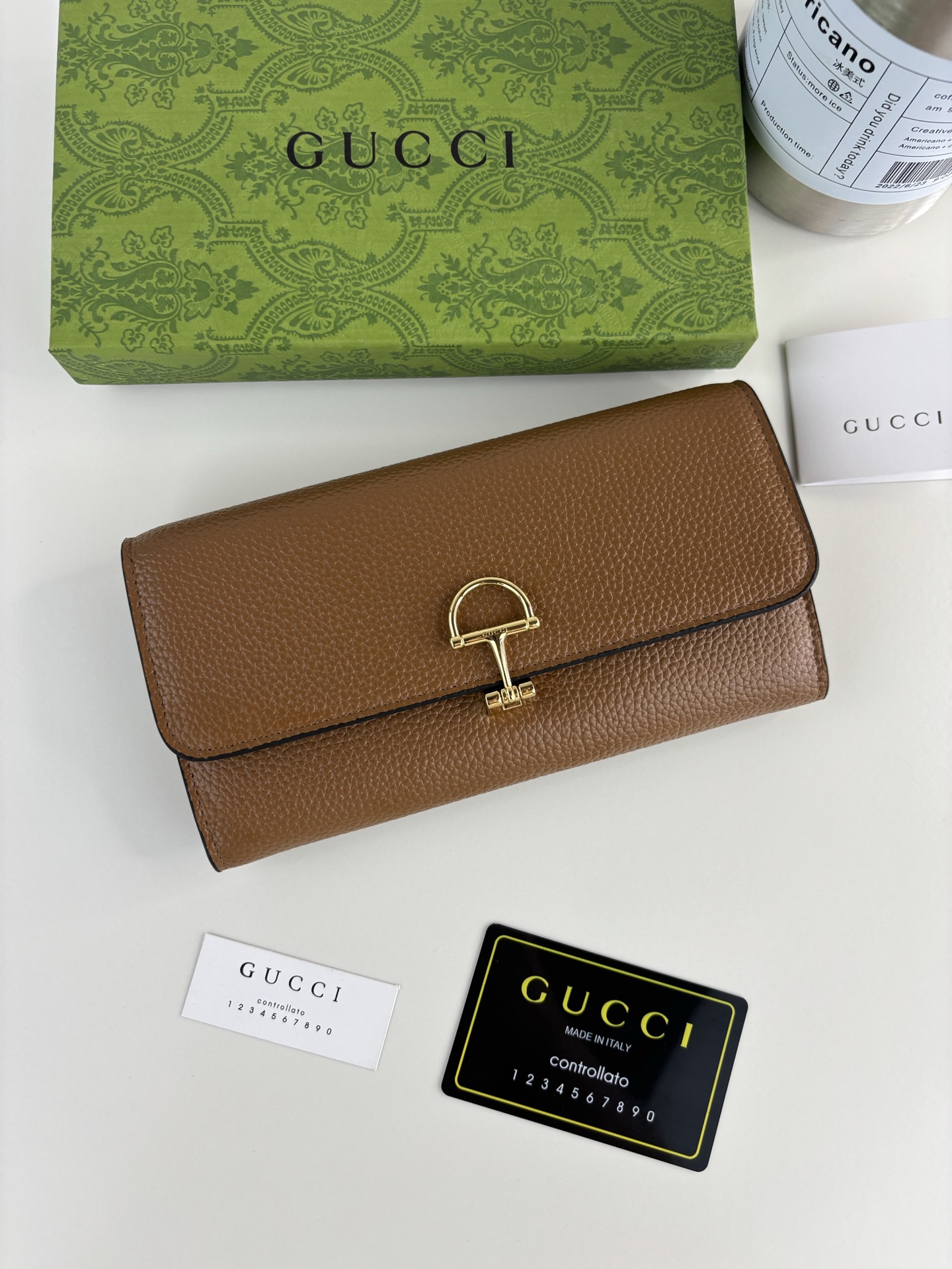 GUCCl 延续品牌深厚传承，深化与马术本源的联结。半马衔扣图案化身为开合细节，为多款小皮件增色添彩。这款长夹以黑色粒面