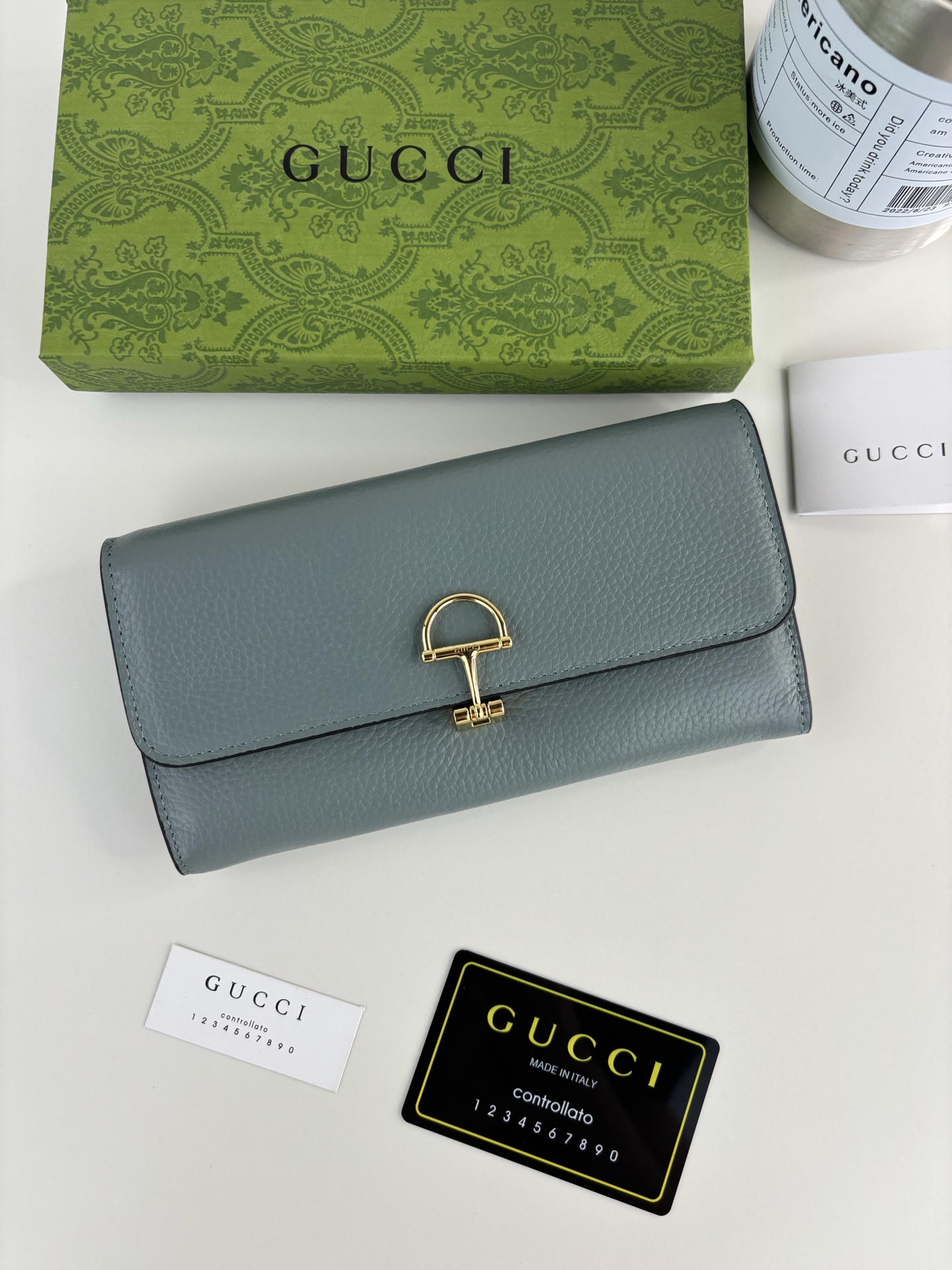 GUCCl 延续品牌深厚传承，深化与马术本源的联结。半马衔扣图案化身为开合细节，为多款小皮件增色添彩。这款长夹以黑色粒面