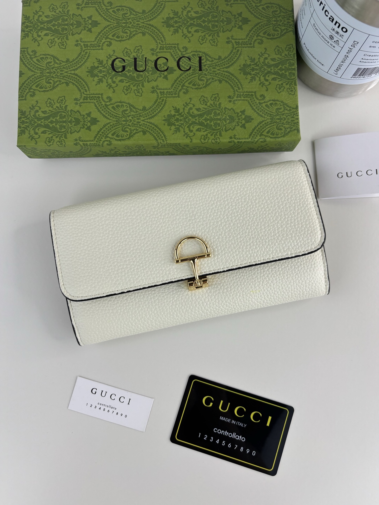 GUCCl 延续品牌深厚传承，深化与马术本源的联结。半马衔扣图案化身为开合细节，为多款小皮件增色添彩。这款长夹以黑色粒面